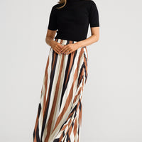 Woman wearing a black top and striped skirt on a white background