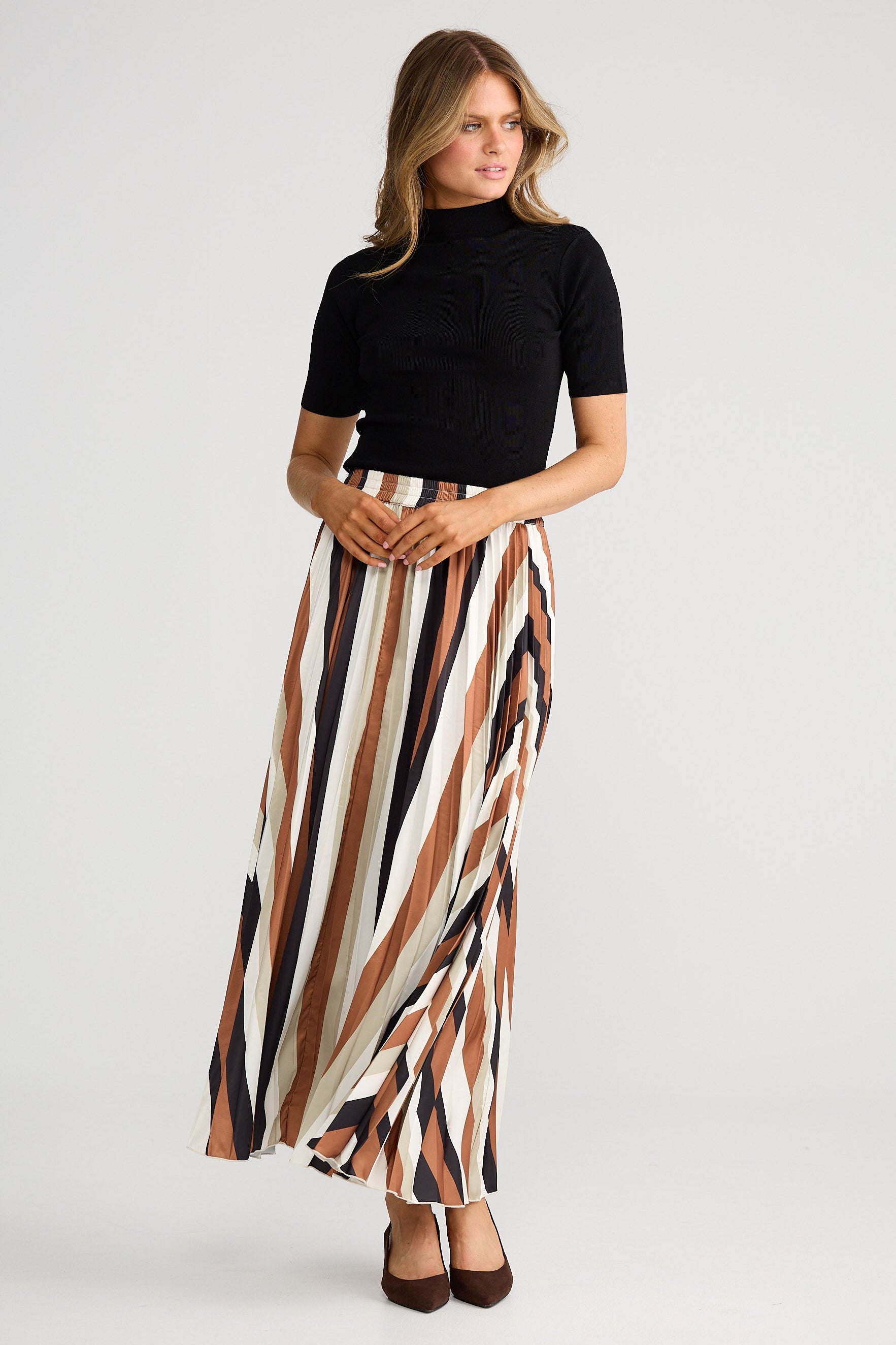 Woman wearing a black top and striped skirt on a white background