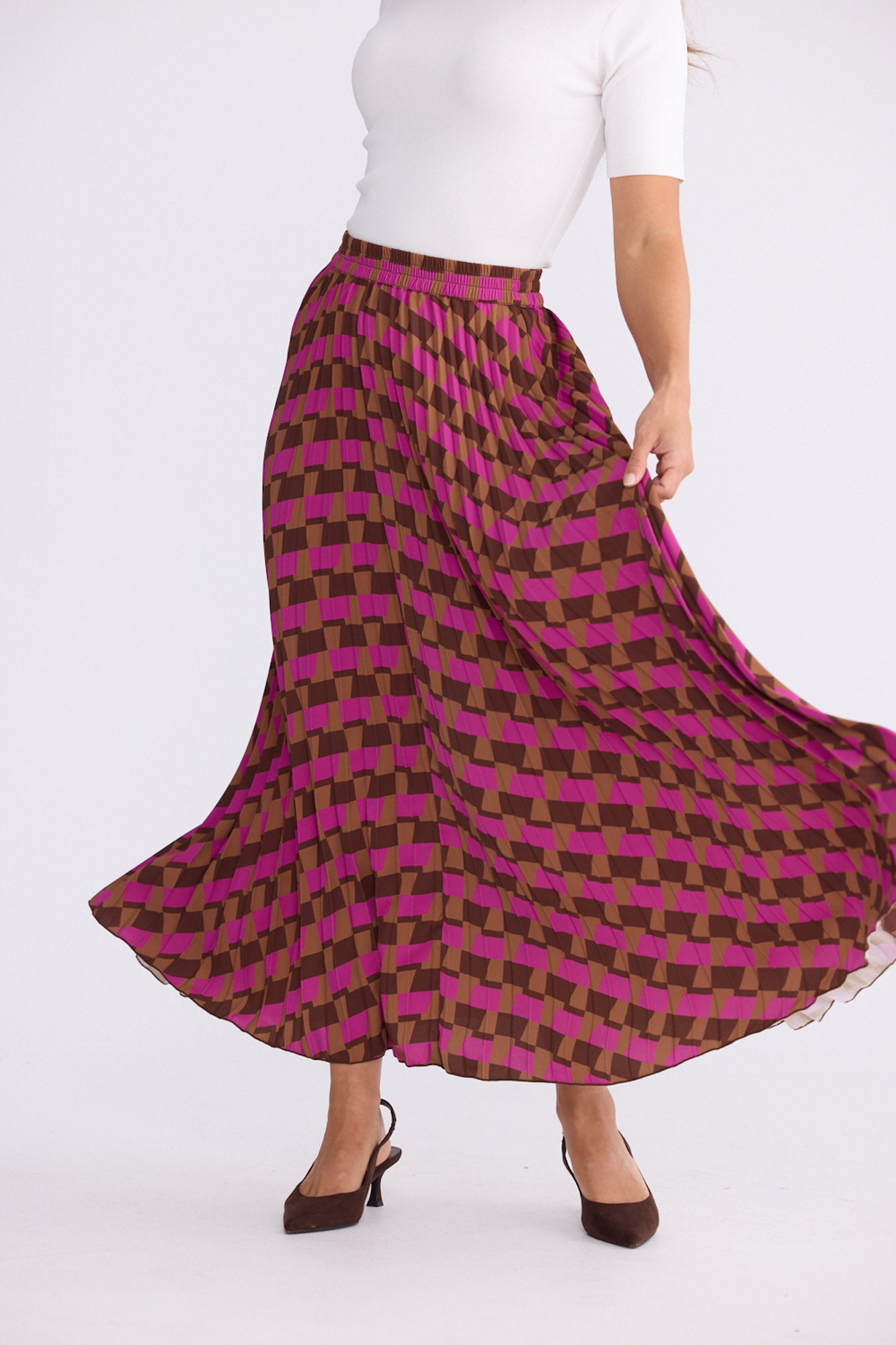 Model wearing Alias Pleated Skirt multicolour geometric-print skirt, alternate studio view on white background