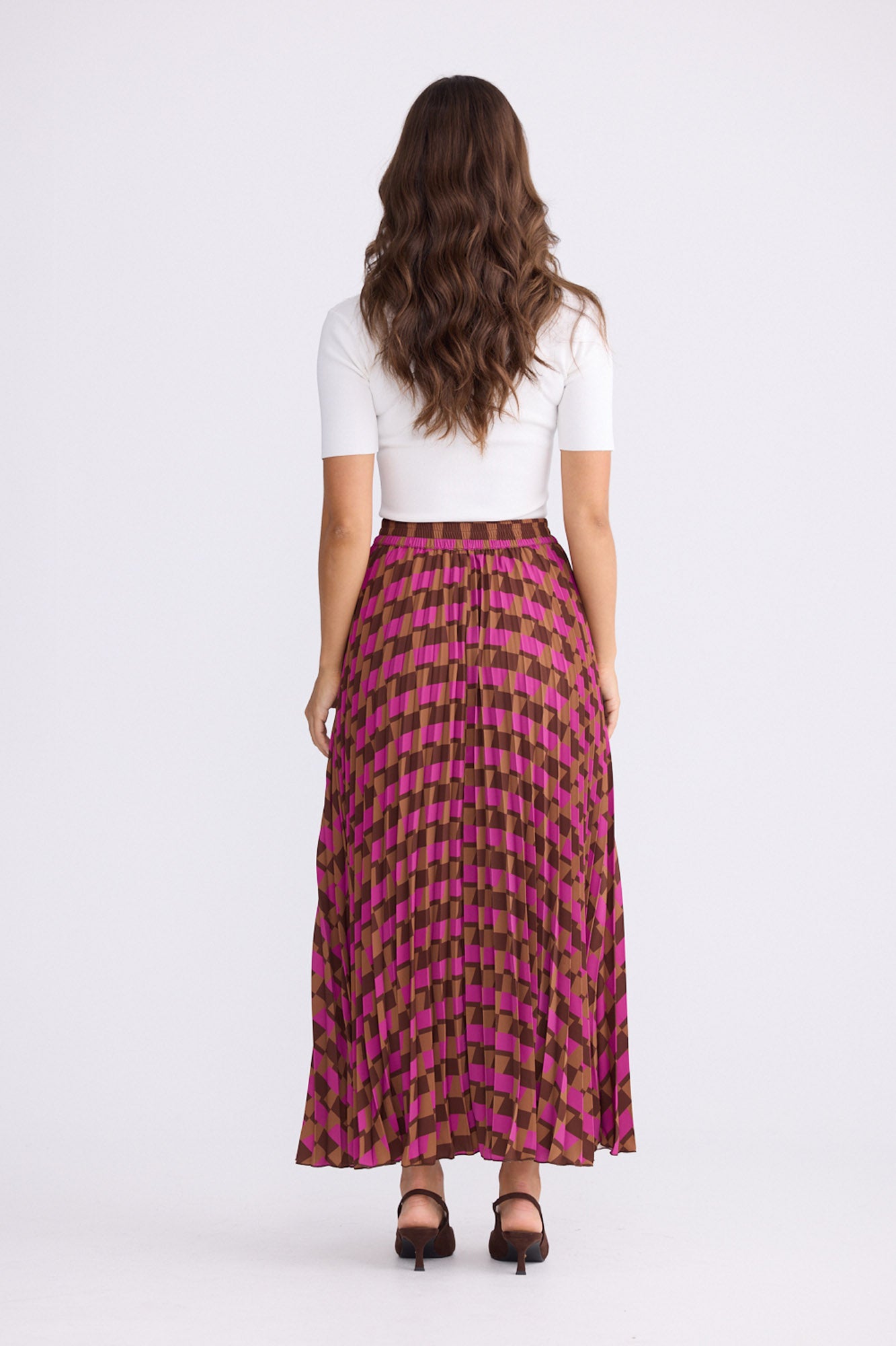 Model wearing Alias Pleated Skirt multicolour geometric-print skirt, alternate studio view on white background