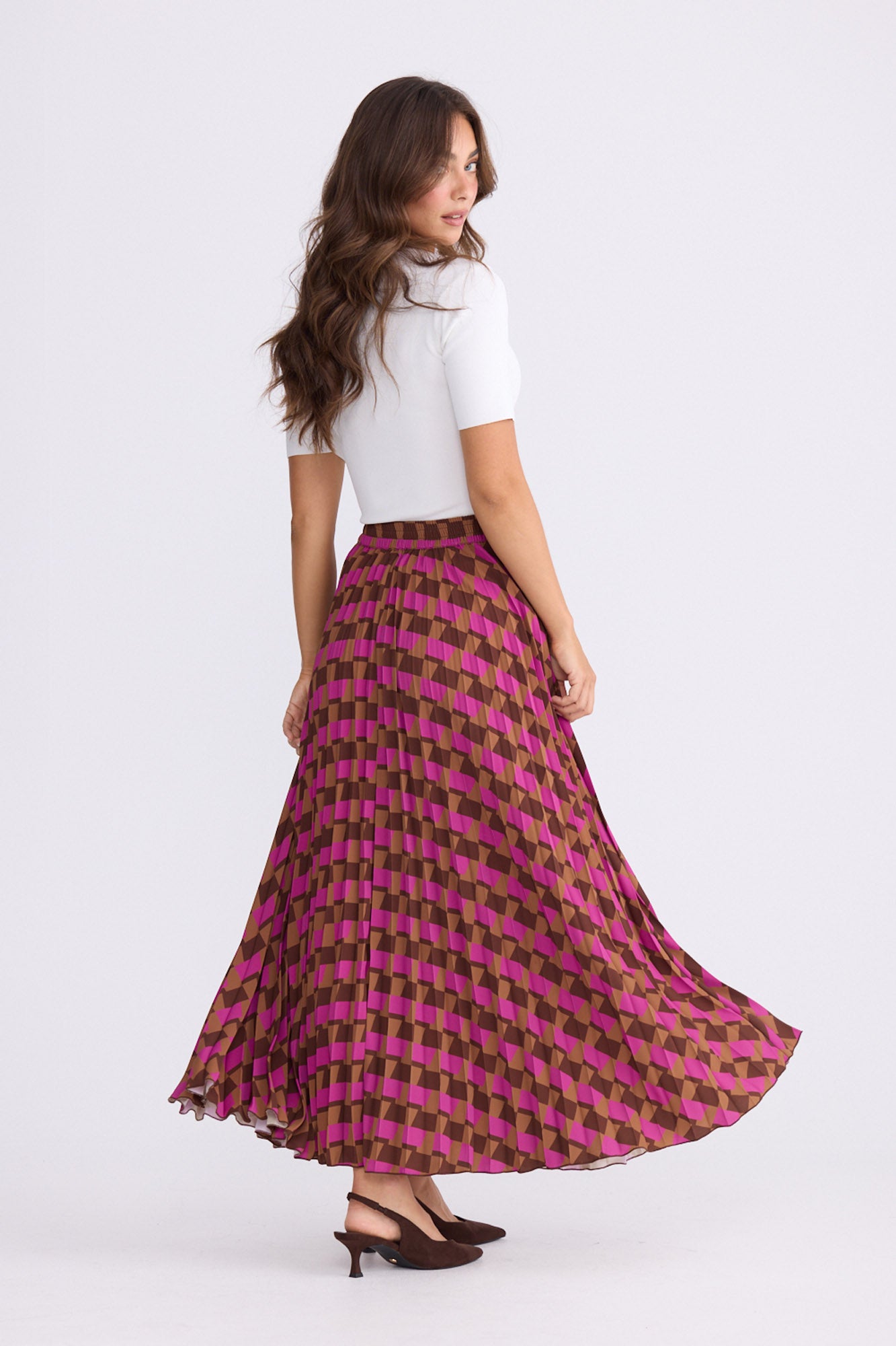 Model wearing Alias Pleated Skirt multicolour geometric-print skirt, alternate studio view on white background