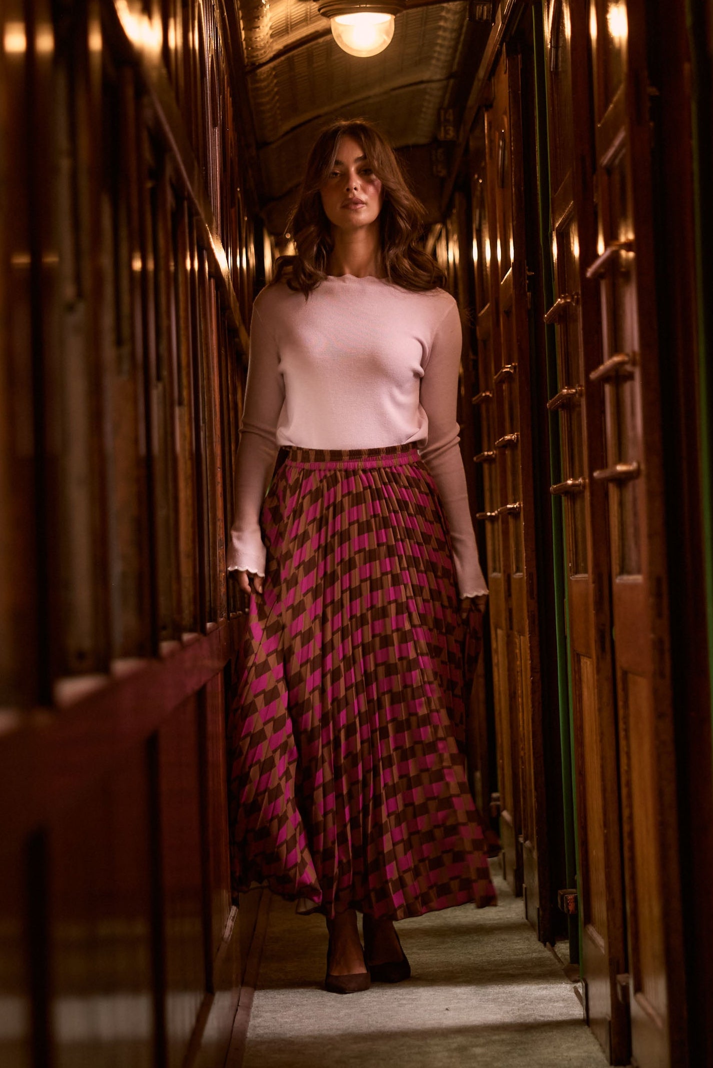 Model wearing Alias Pleated Skirt in a multicolour geometric-print skirt