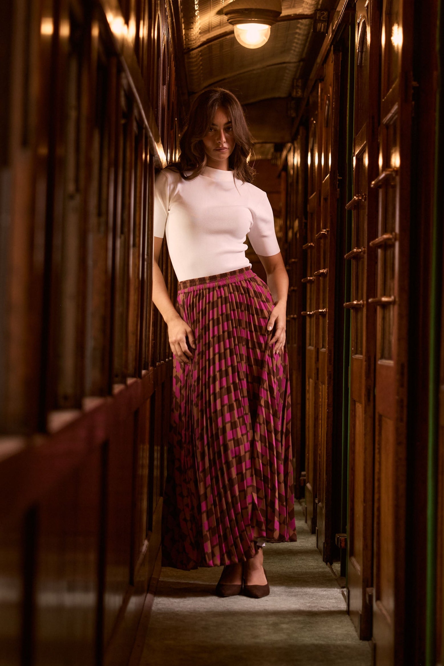 Model wearing Alias Pleated Skirt in a multicolour geometric print
