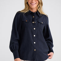 Woman wearing a navy blue shirt with buttons on a white background