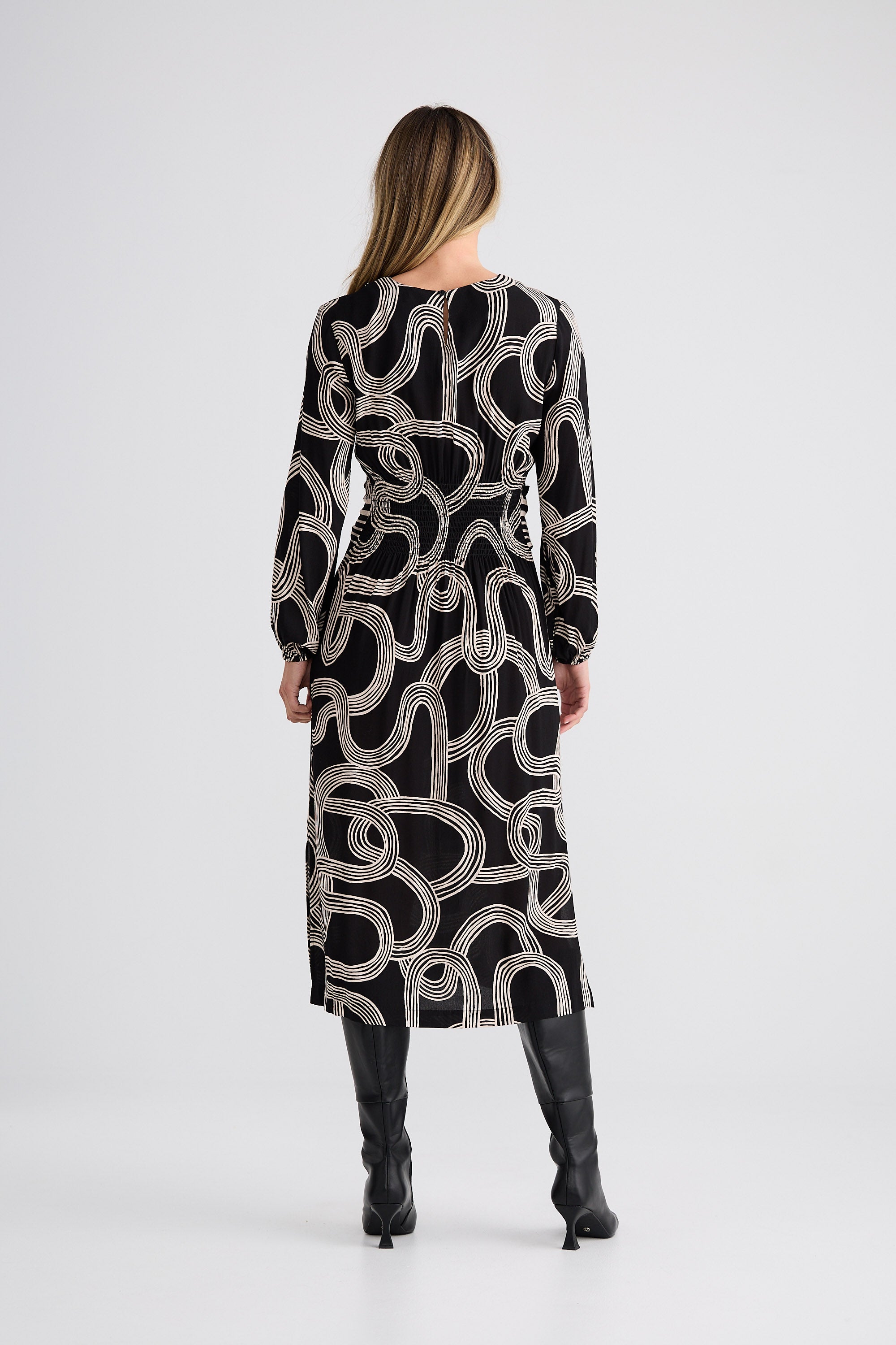 Woman wearing a black and white patterned dress on a white background