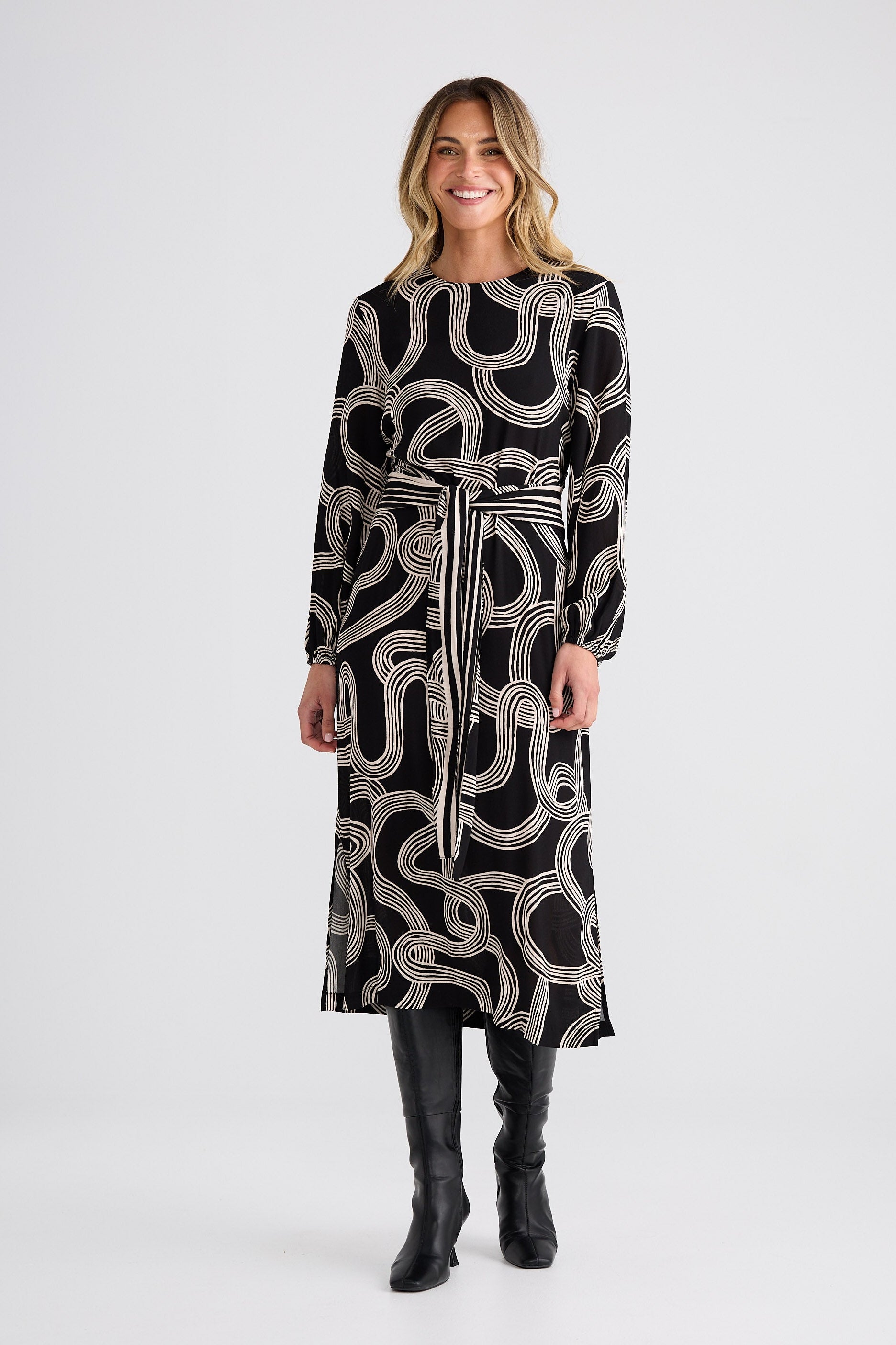 Woman wearing a black dress with white pattern on a white background