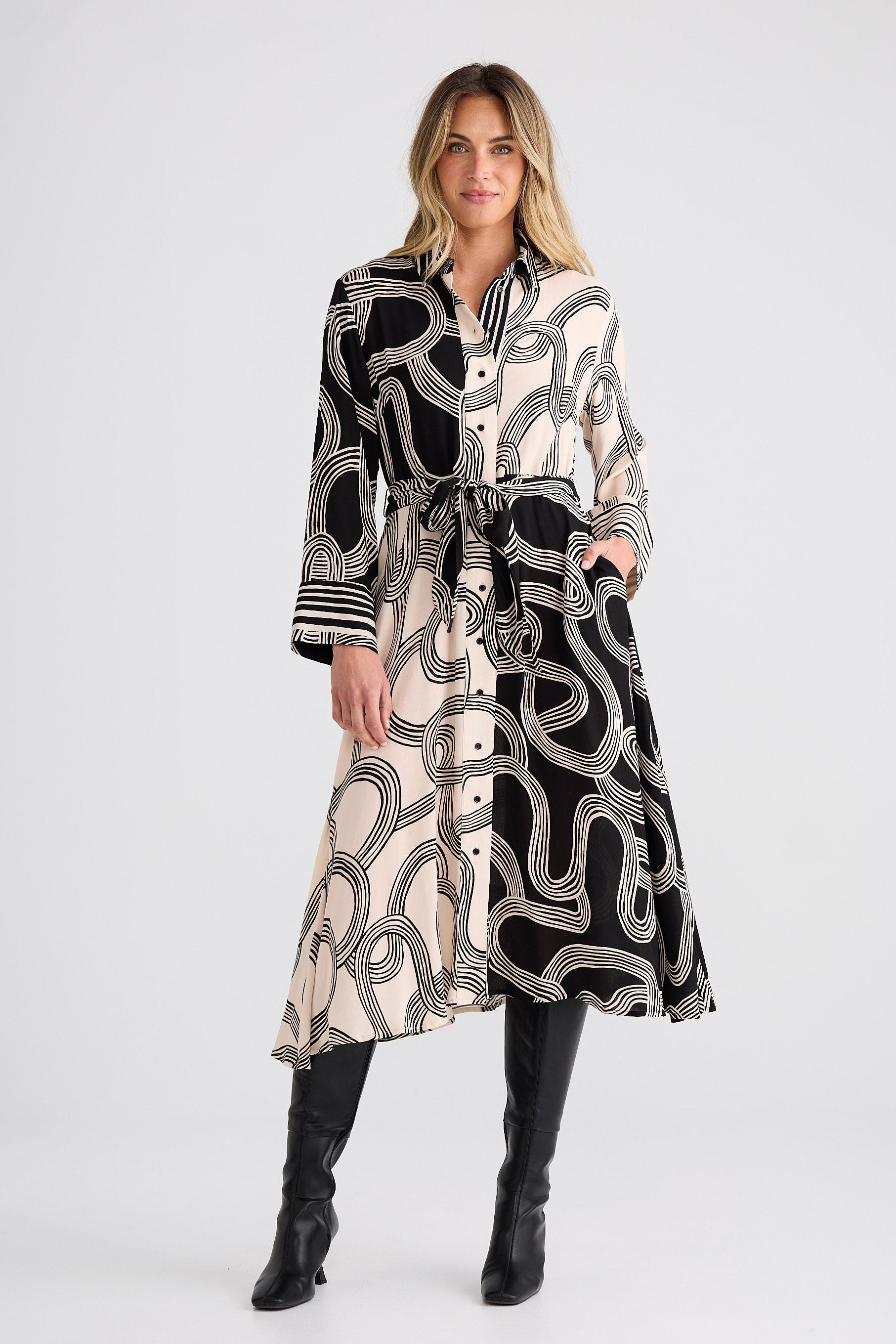 Woman wearing a black and white patterned dress on a white background