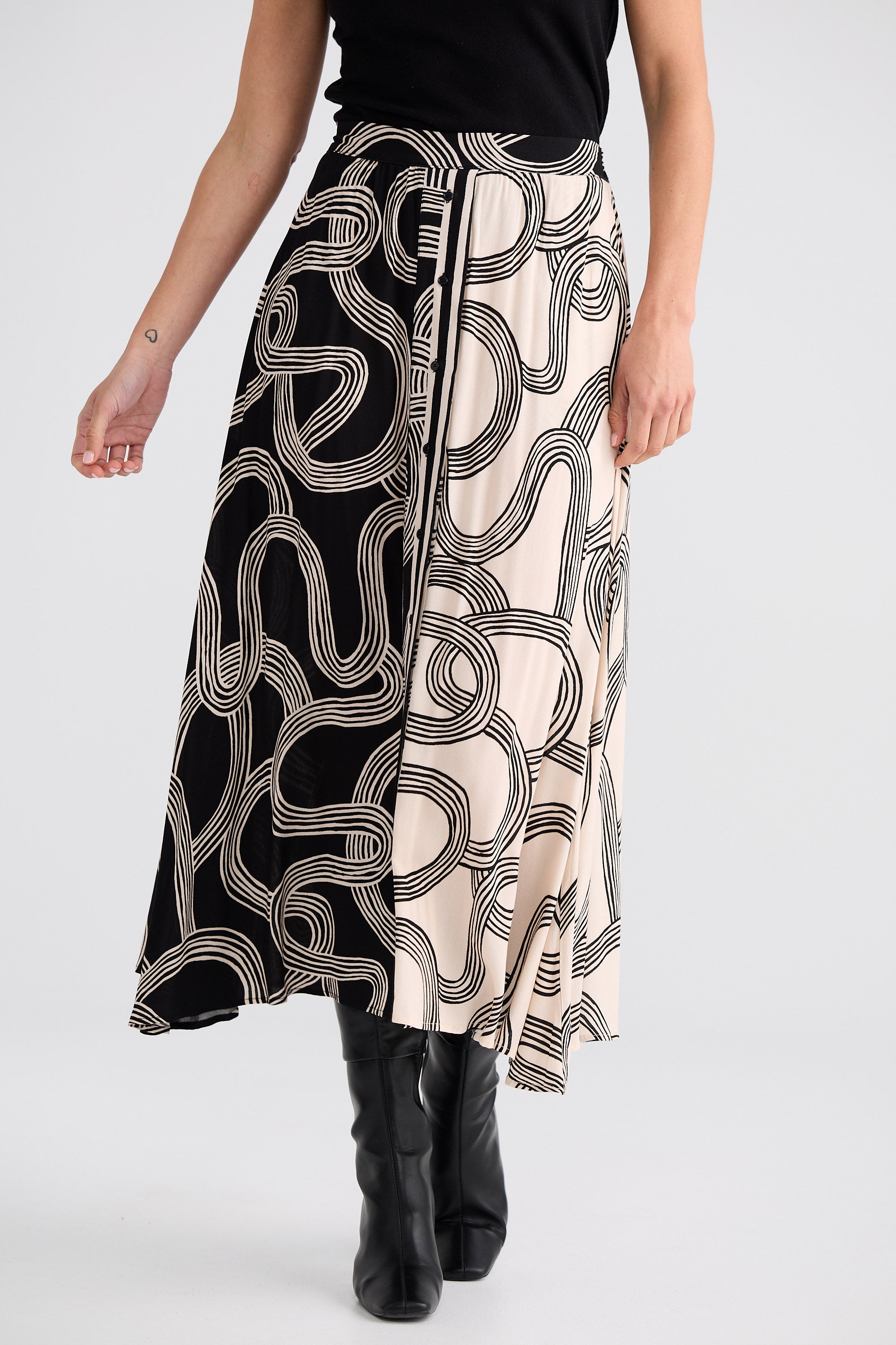 Person wearing a black and white patterned skirt on a white background