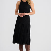 Woman wearing a black dress and brown boots on a white background
