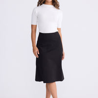 Model wearing Oriane Skirt in black, front view on white background