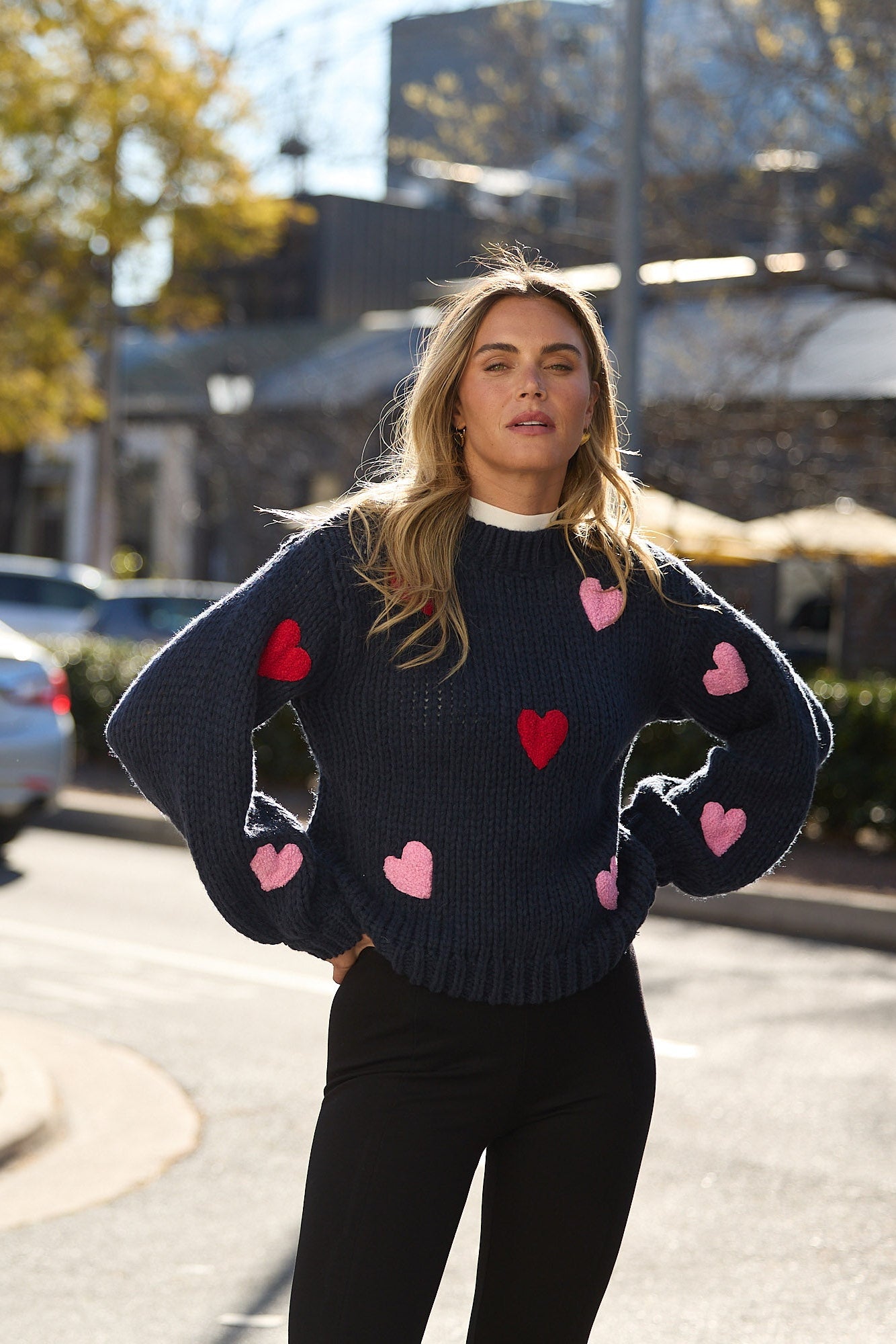 Woman wearing a sweater with heart patterns on a street