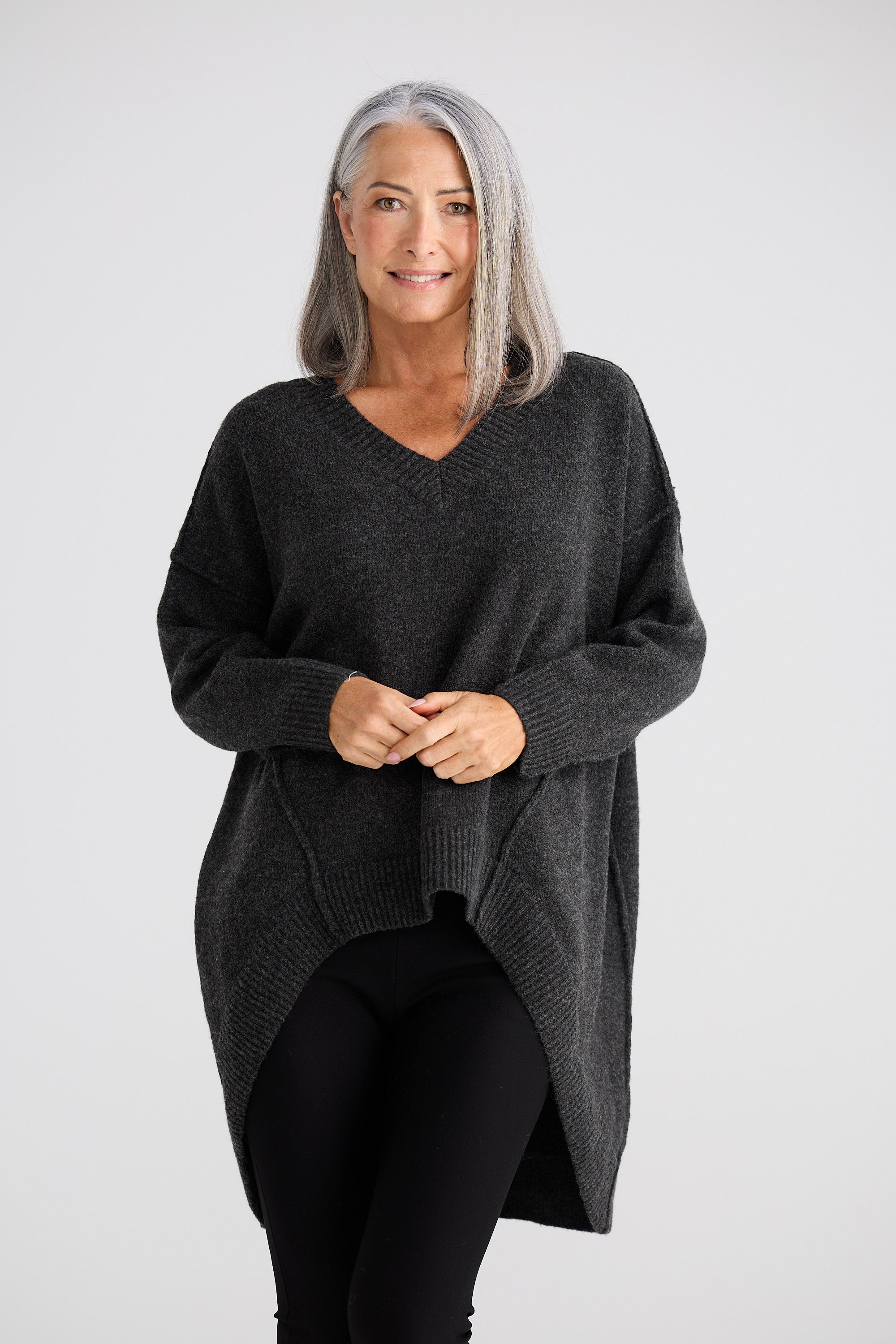 Woman wearing a dark gray sweater on a white background