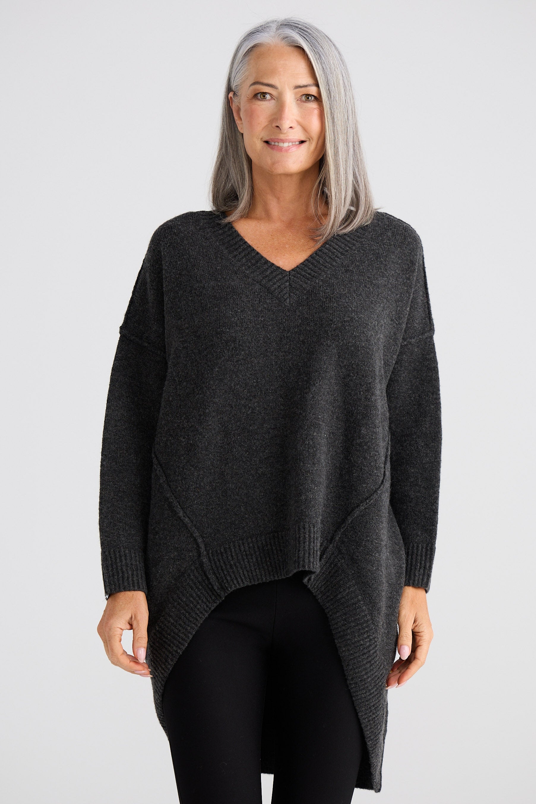 Woman wearing a dark gray sweater on a light gray background