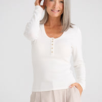 Woman wearing a white blouse with a plain background