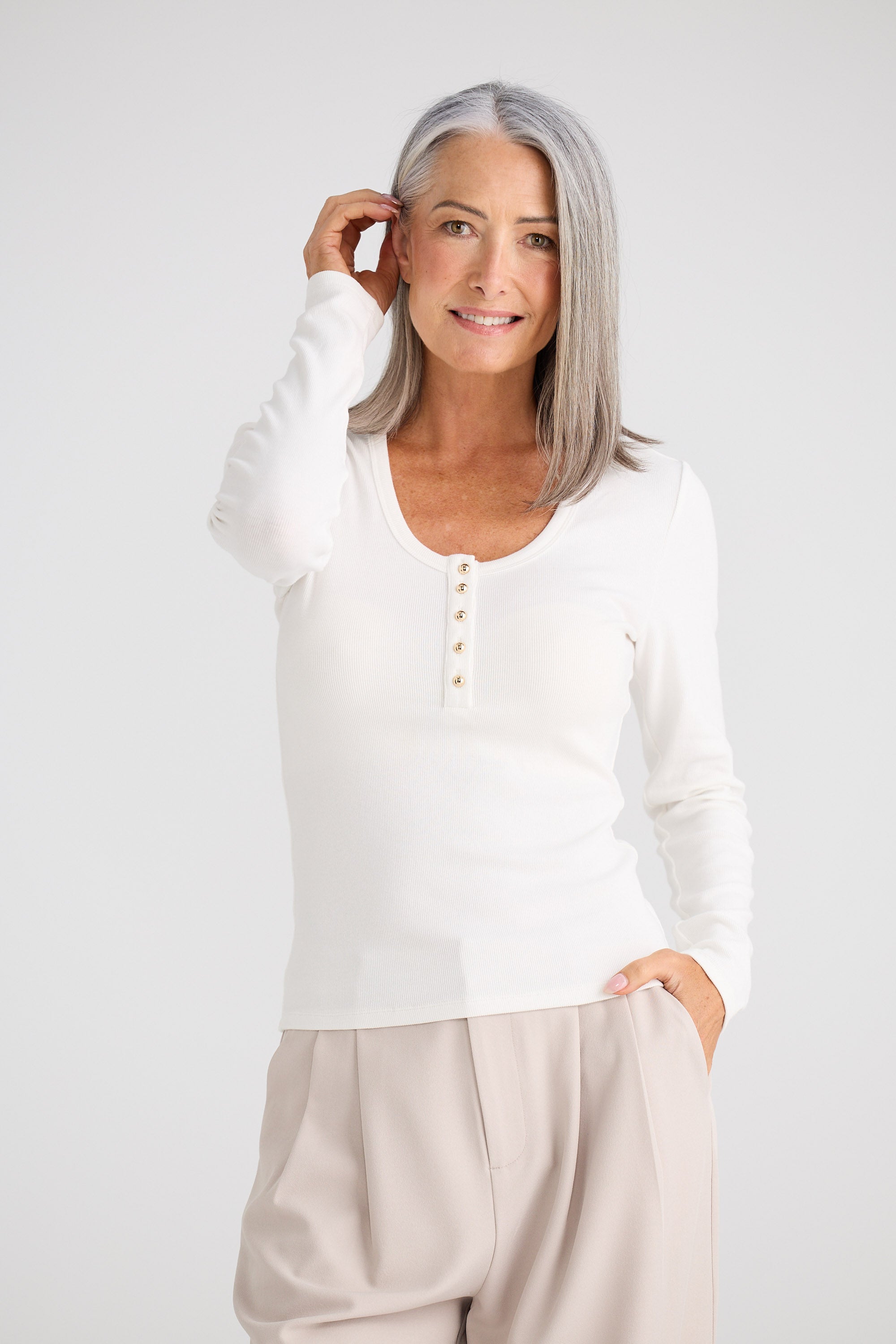 Woman wearing a white blouse with a plain background