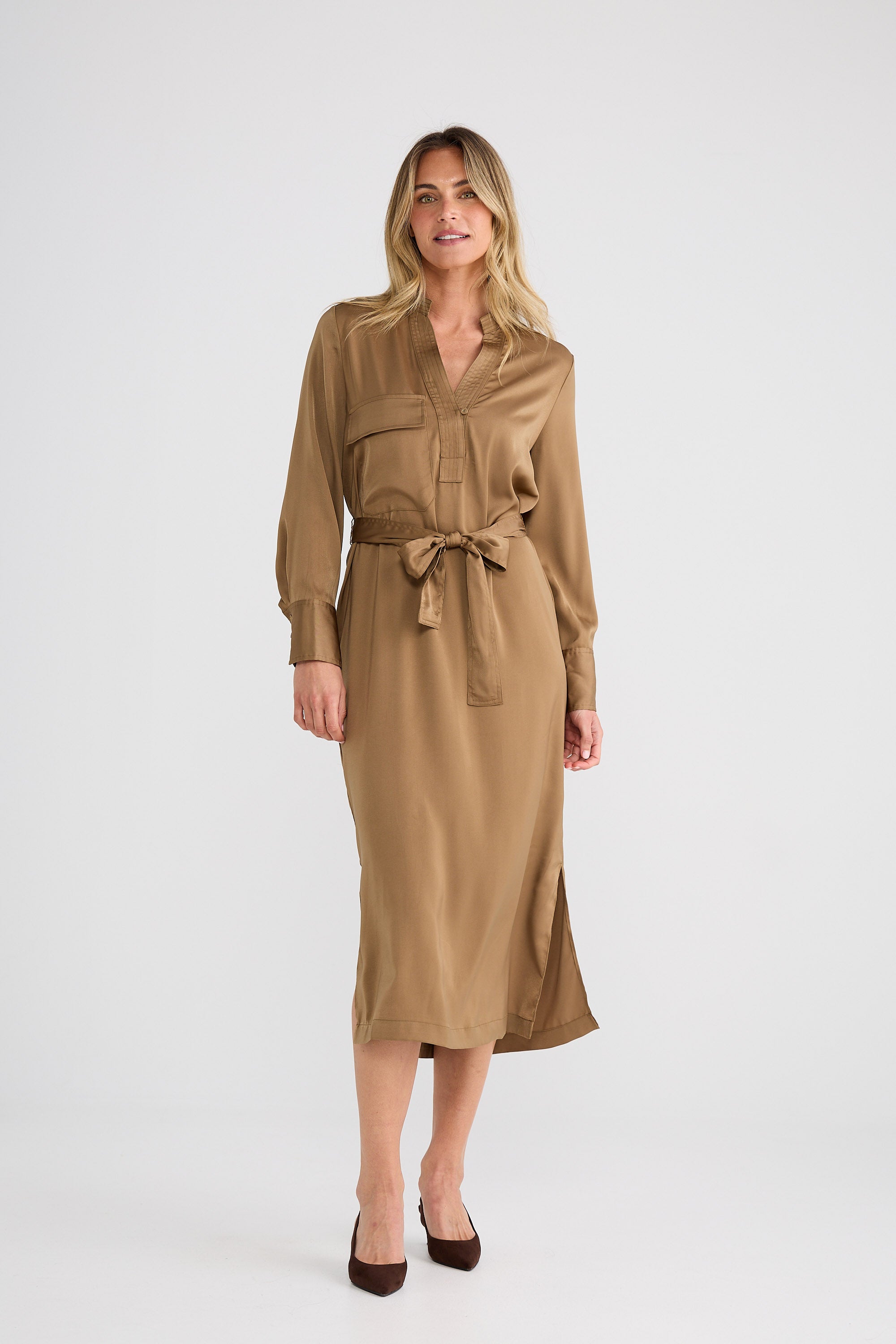 Woman wearing a brown dress with a belt on a white background