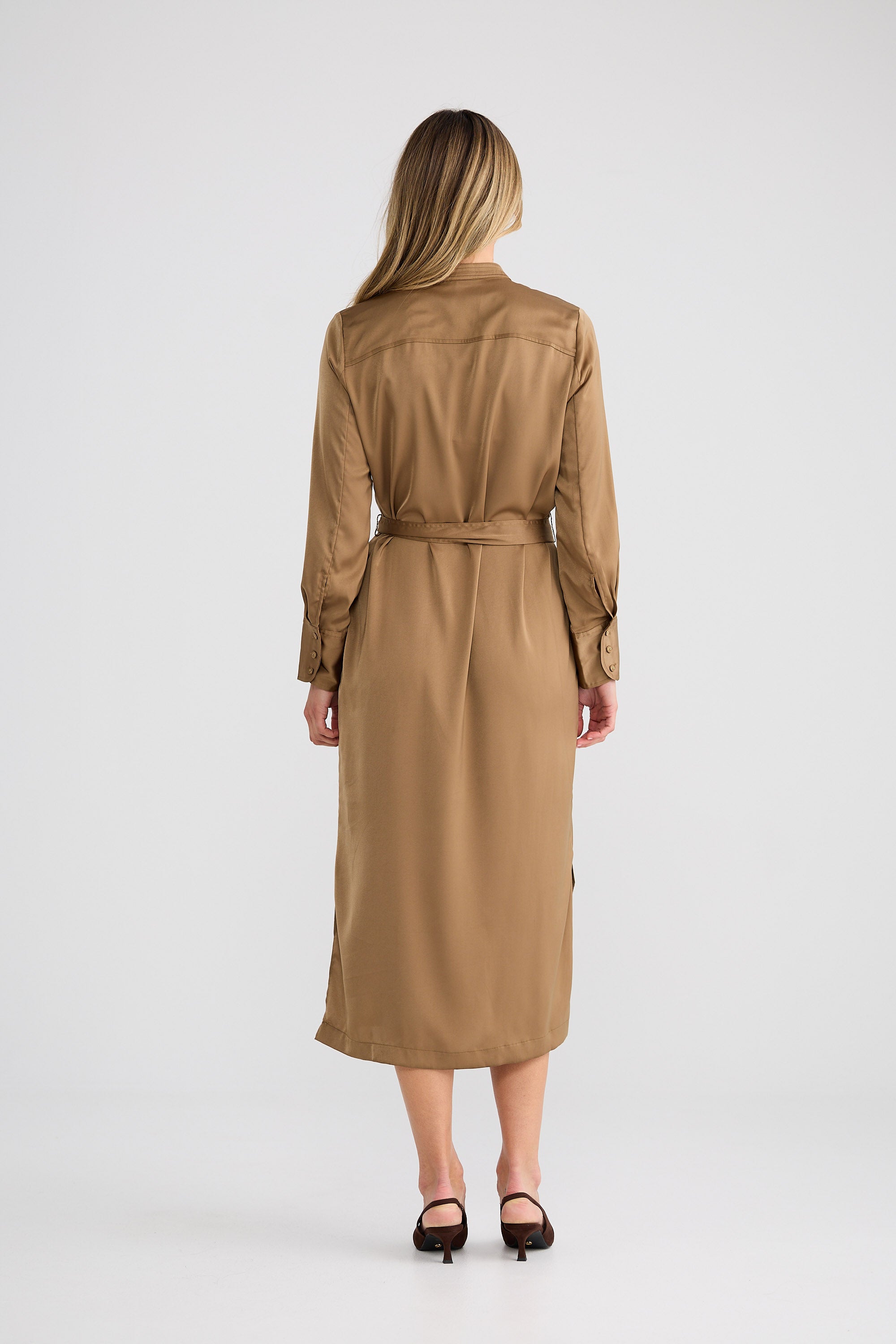 Woman wearing a long beige trench coat on a white background