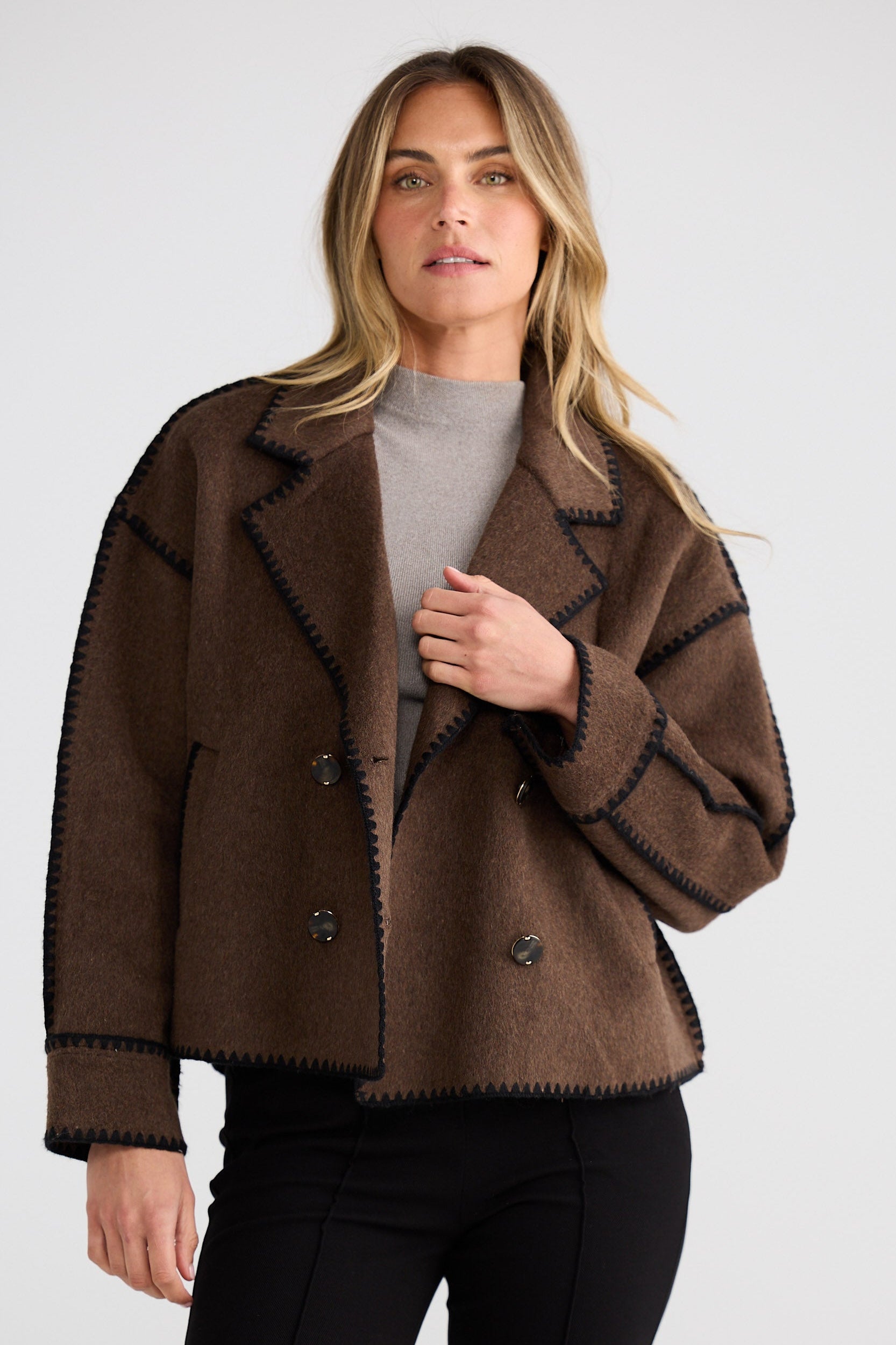 Woman wearing a brown jacket on a white background