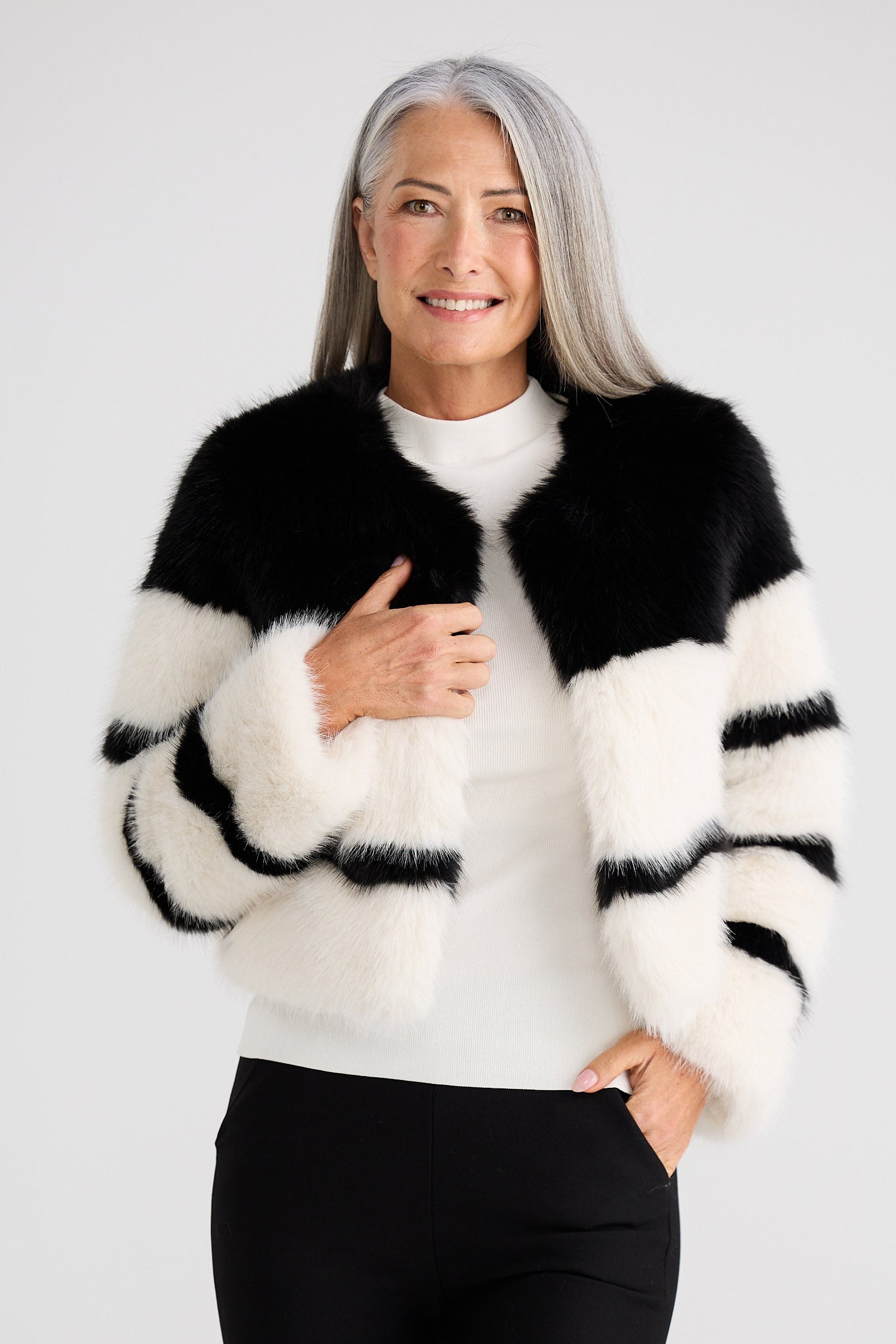 Woman wearing a black and white striped sweater on a plain background