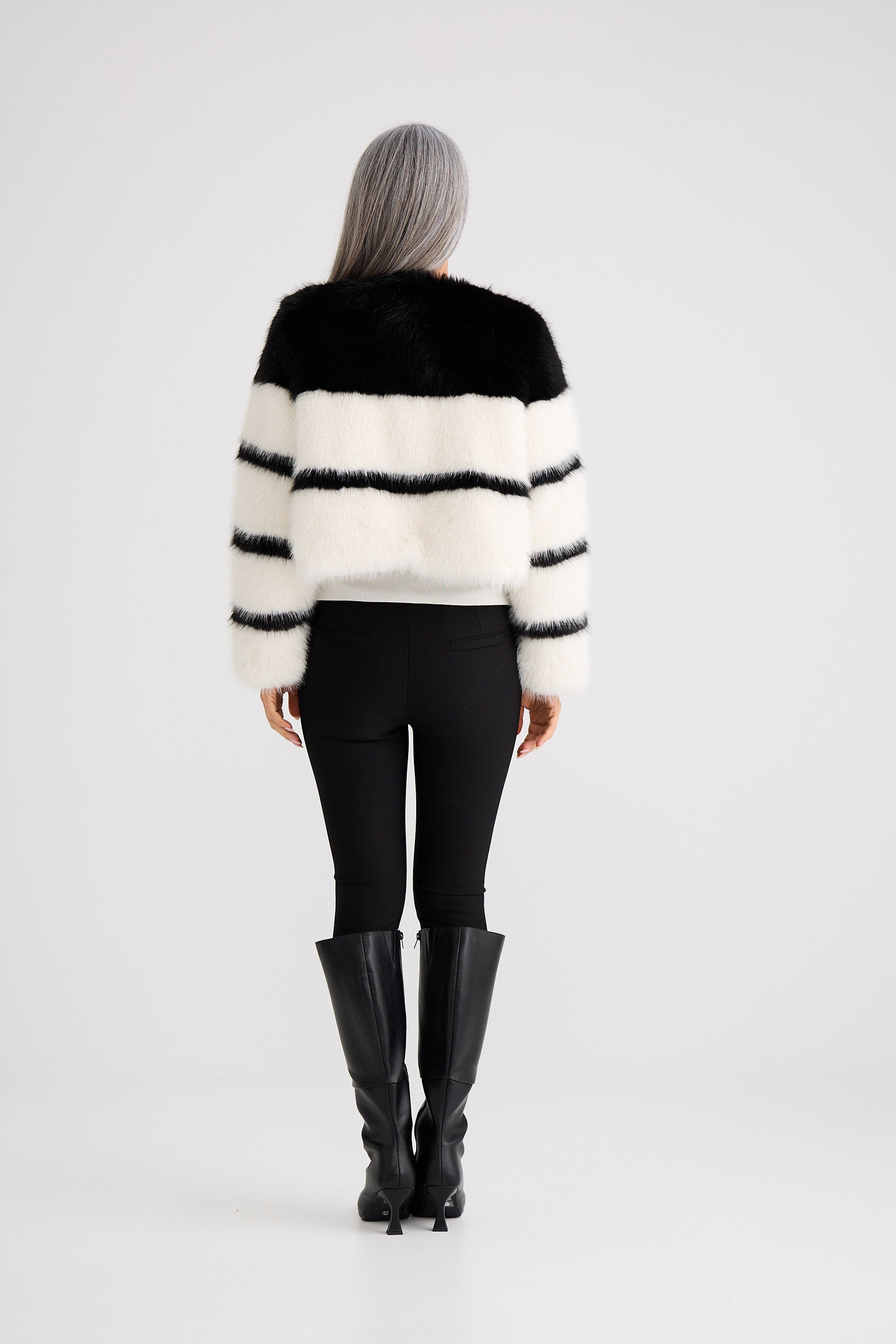 Person wearing a black and white striped sweater on a white background