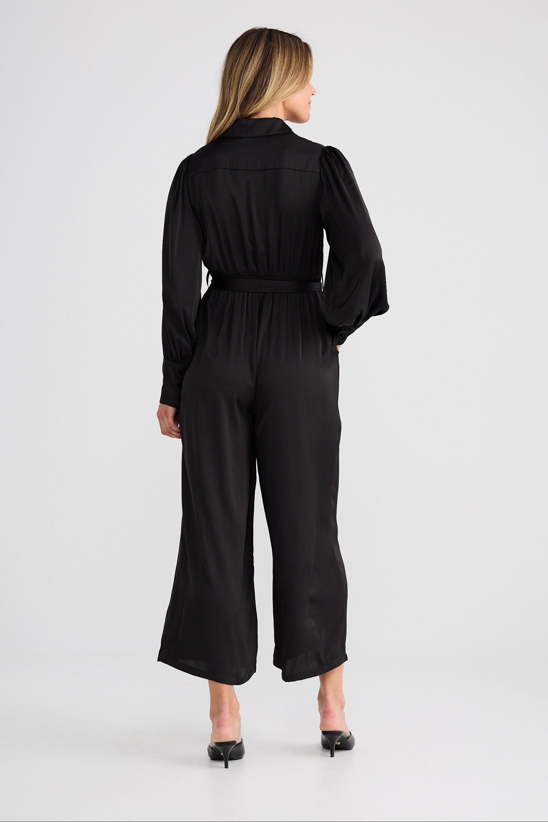 Woman wearing a black jumpsuit on a white background