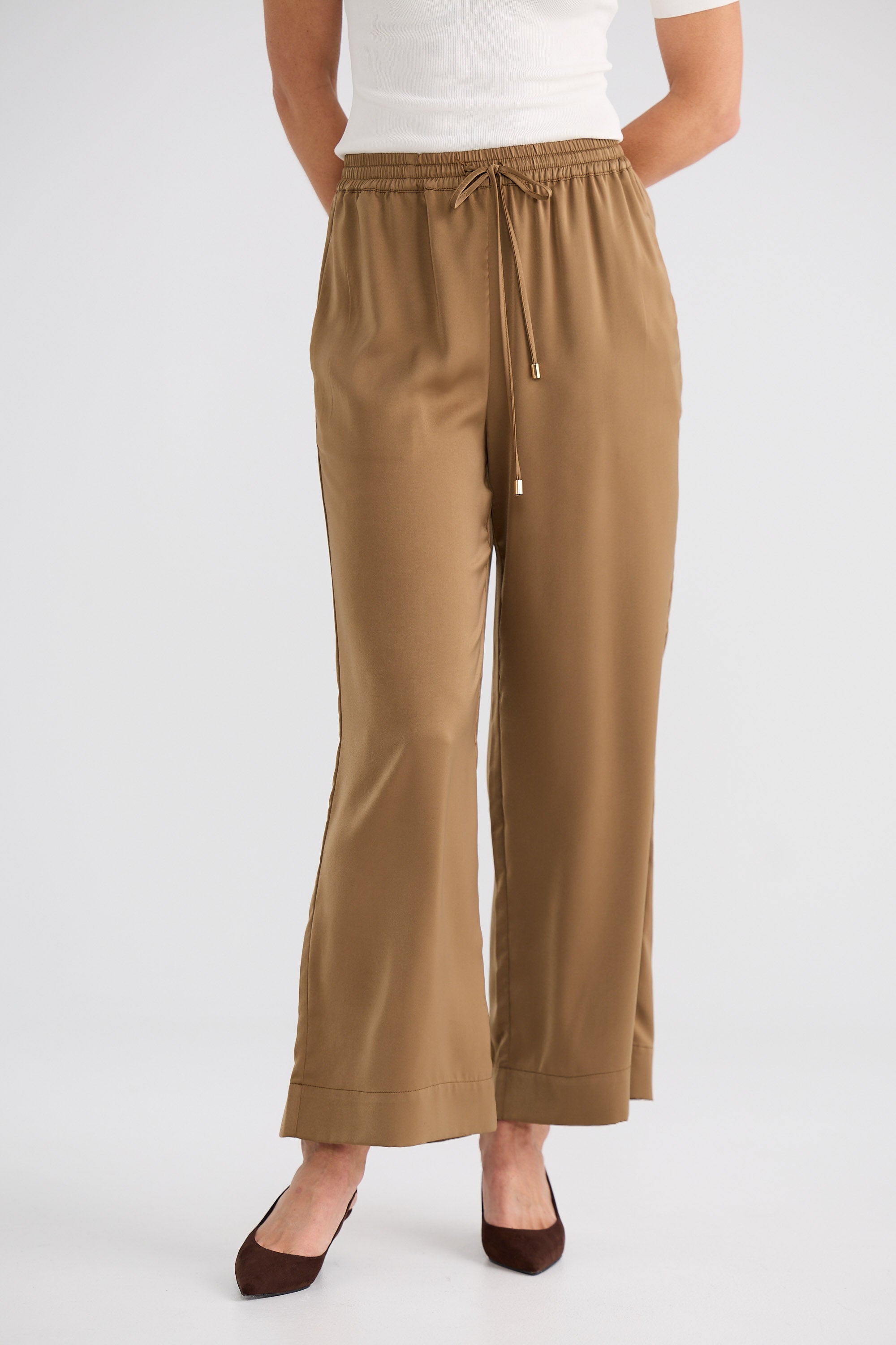 Tan pants worn by a person on a white background