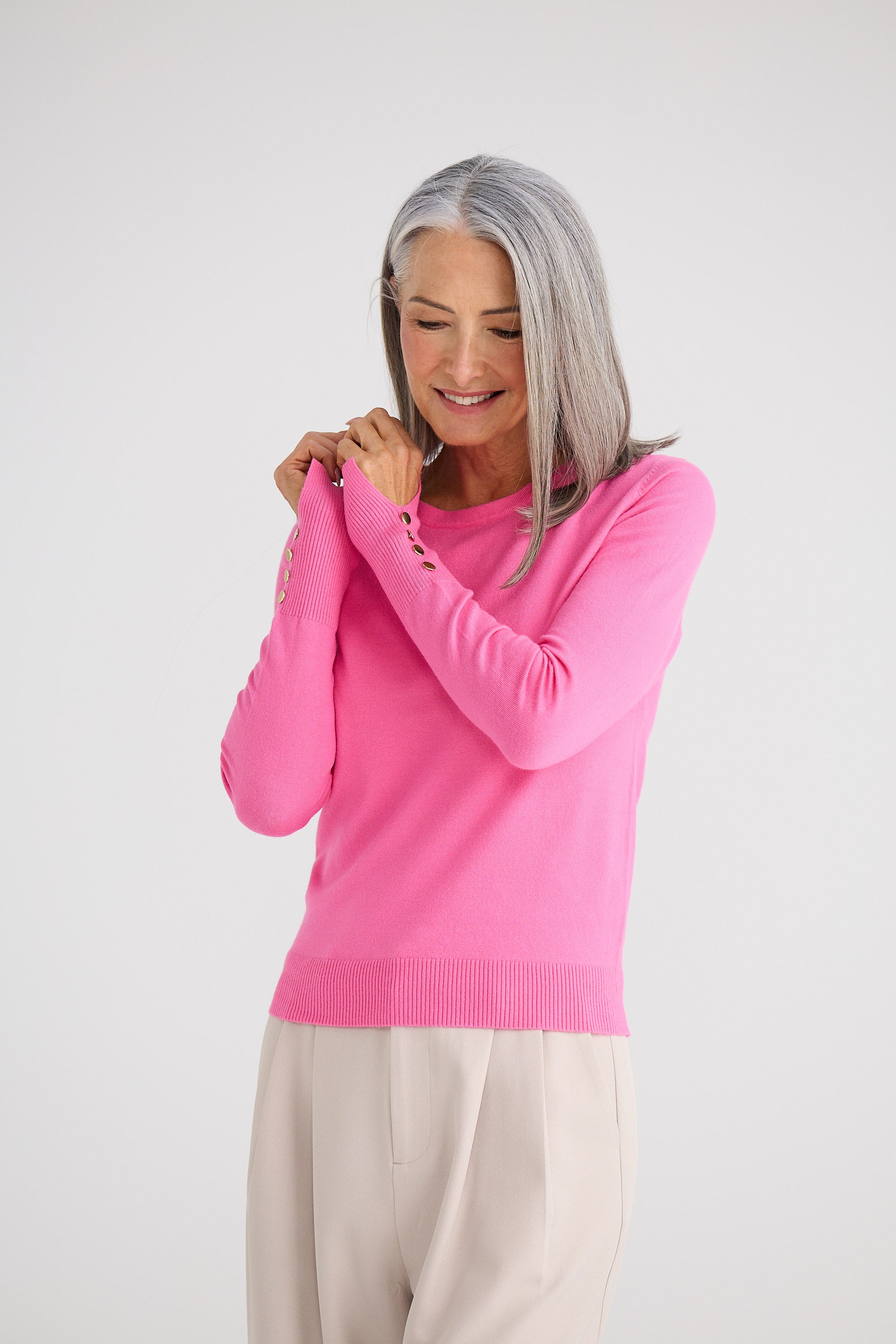 Woman wearing a pink sweater against a white background