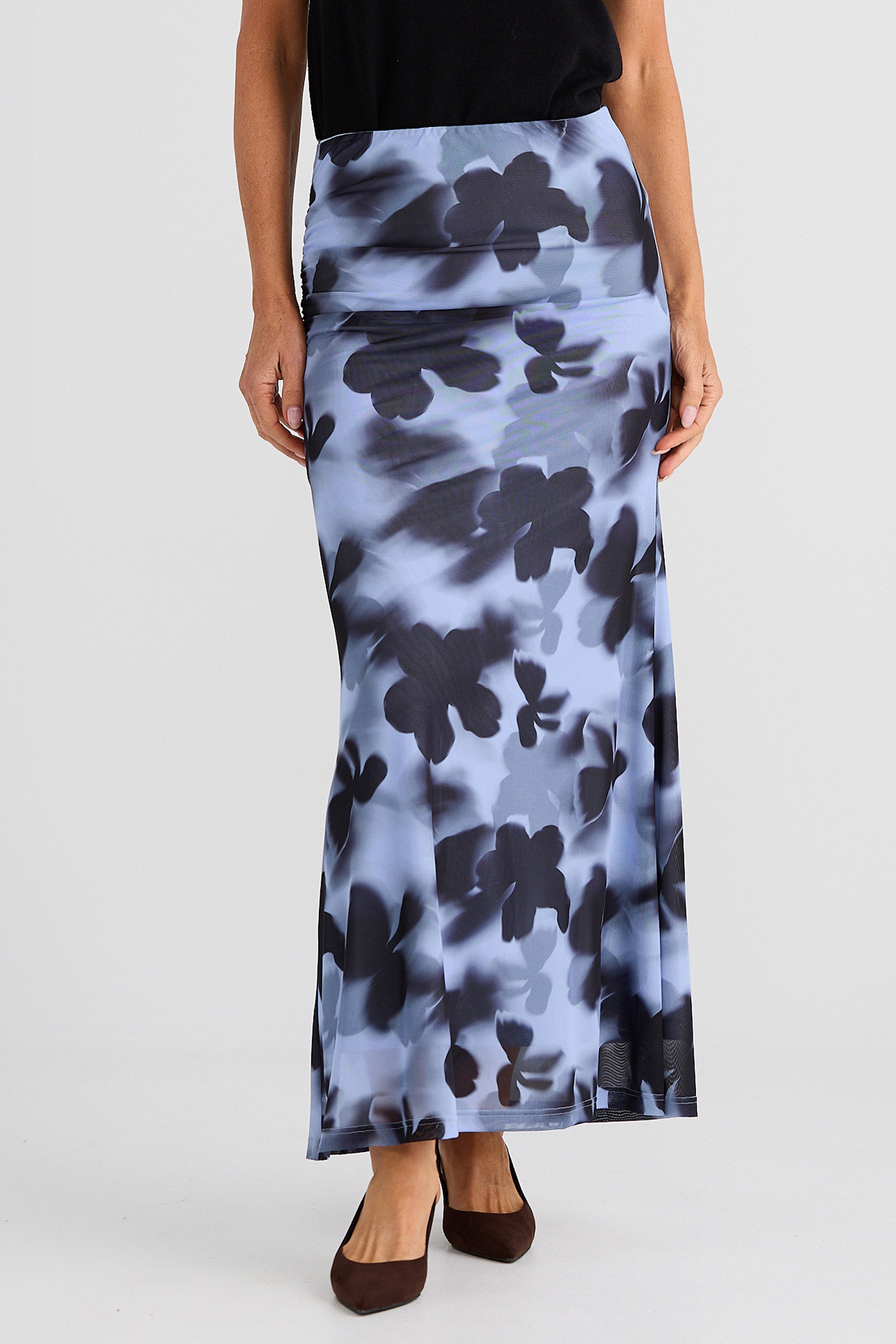 Person wearing a long floral skirt on a white background