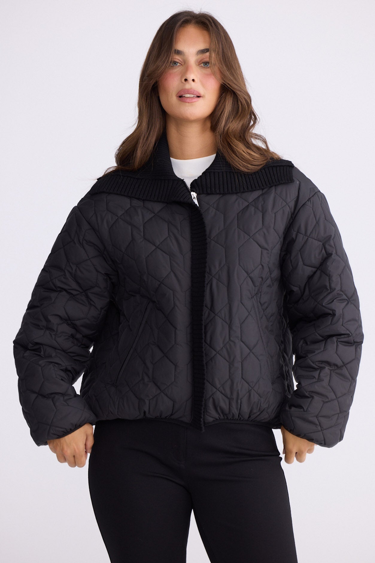 Model wearing Devin Puffer black puffer jacket, wide ribbed contrast collar and placket, front view on white background