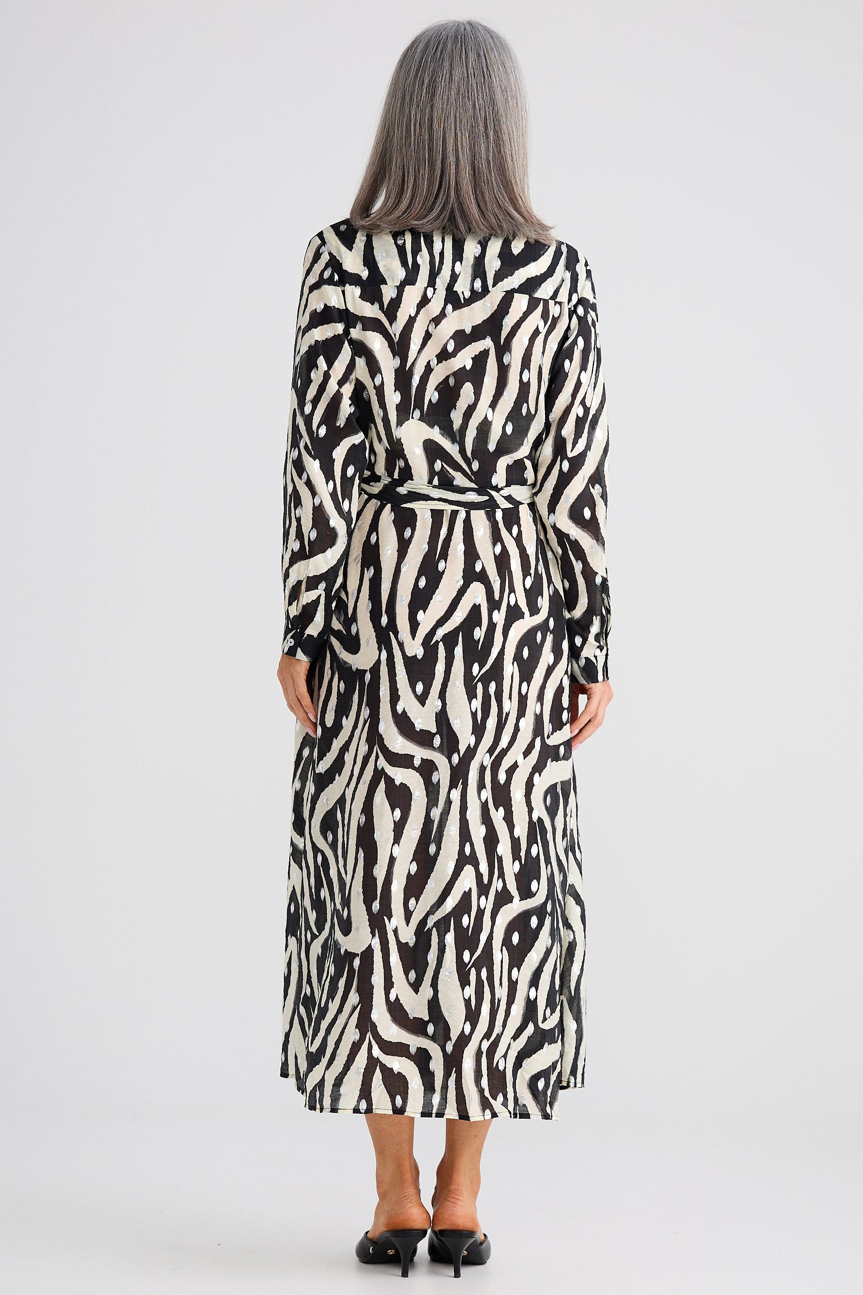 Woman wearing a zebra print dress on a white background