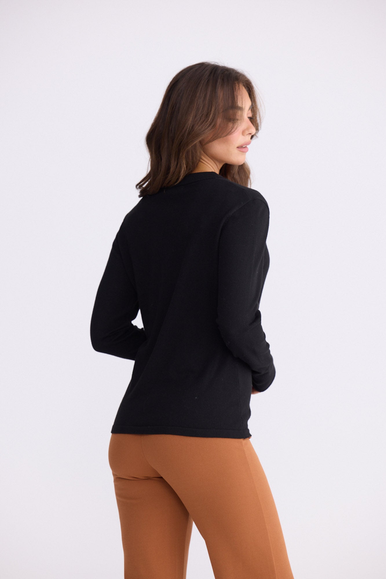 Model wearing Cassian LS Knit Top - Black, alternate studio view on white background