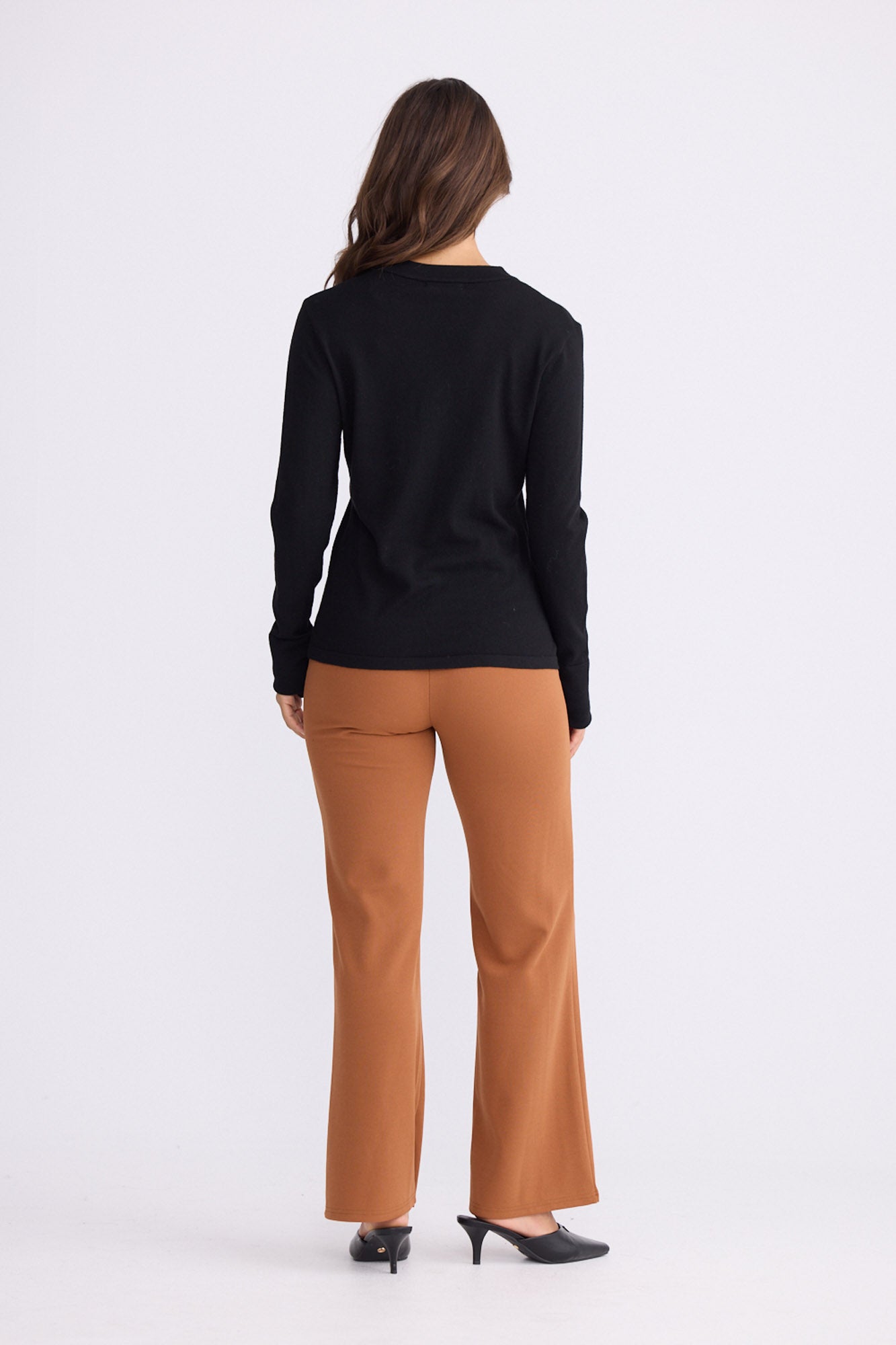 Model wearing Cassian LS Knit Top - Black, alternate studio view on white background