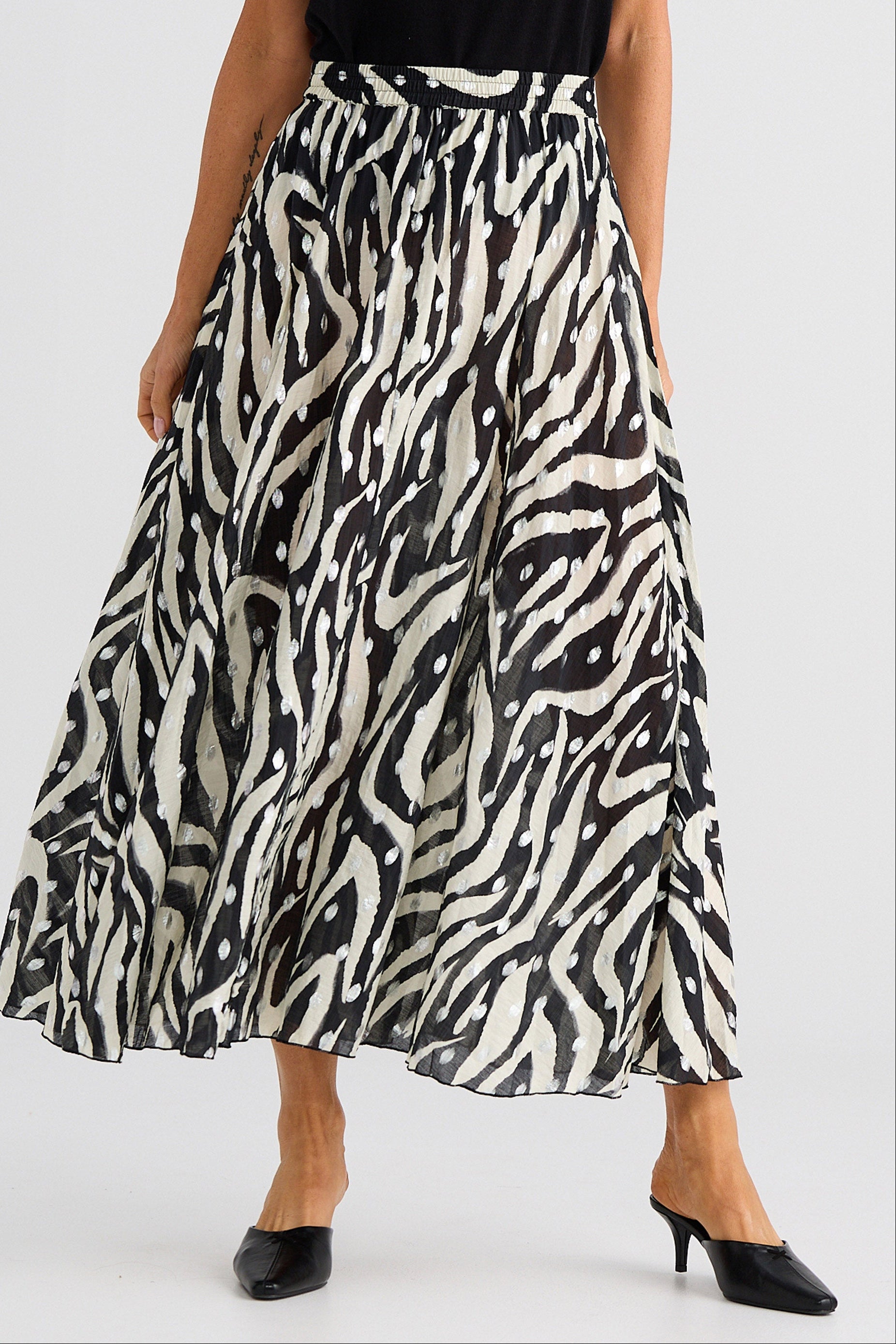 Person wearing a zebra print skirt on a white background