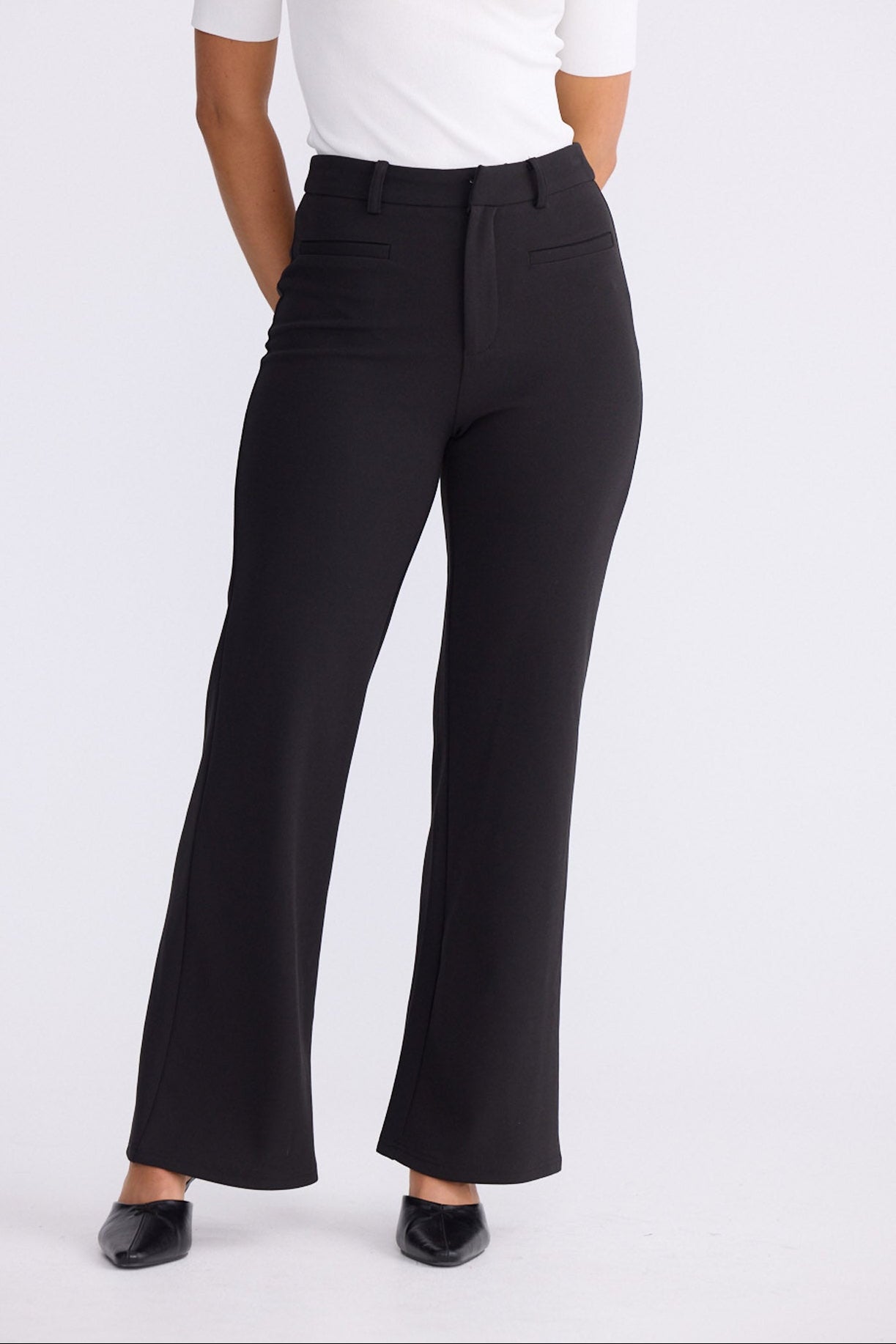 Model wearing Tressa black flared pants with high-rise waist, alternate view on white background