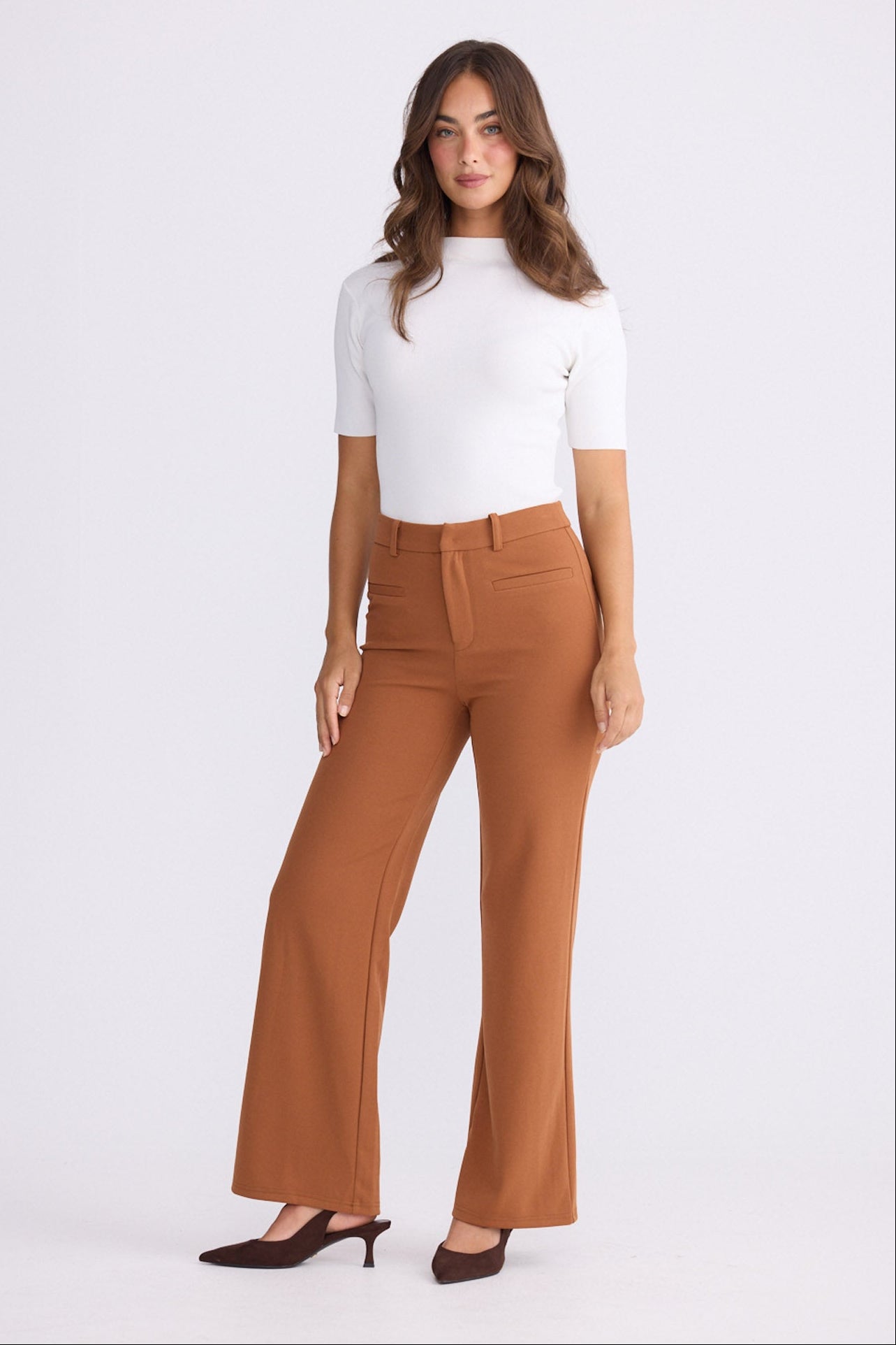 Model wearing Tressa pecan flared pants with high-rise waist, front view on white background
