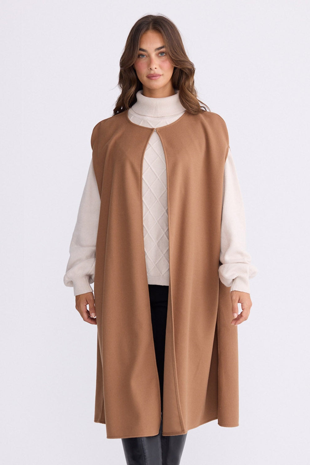 Model wearing Trini camel sleeveless cape with long fluid silhouette, alternate view on white background
