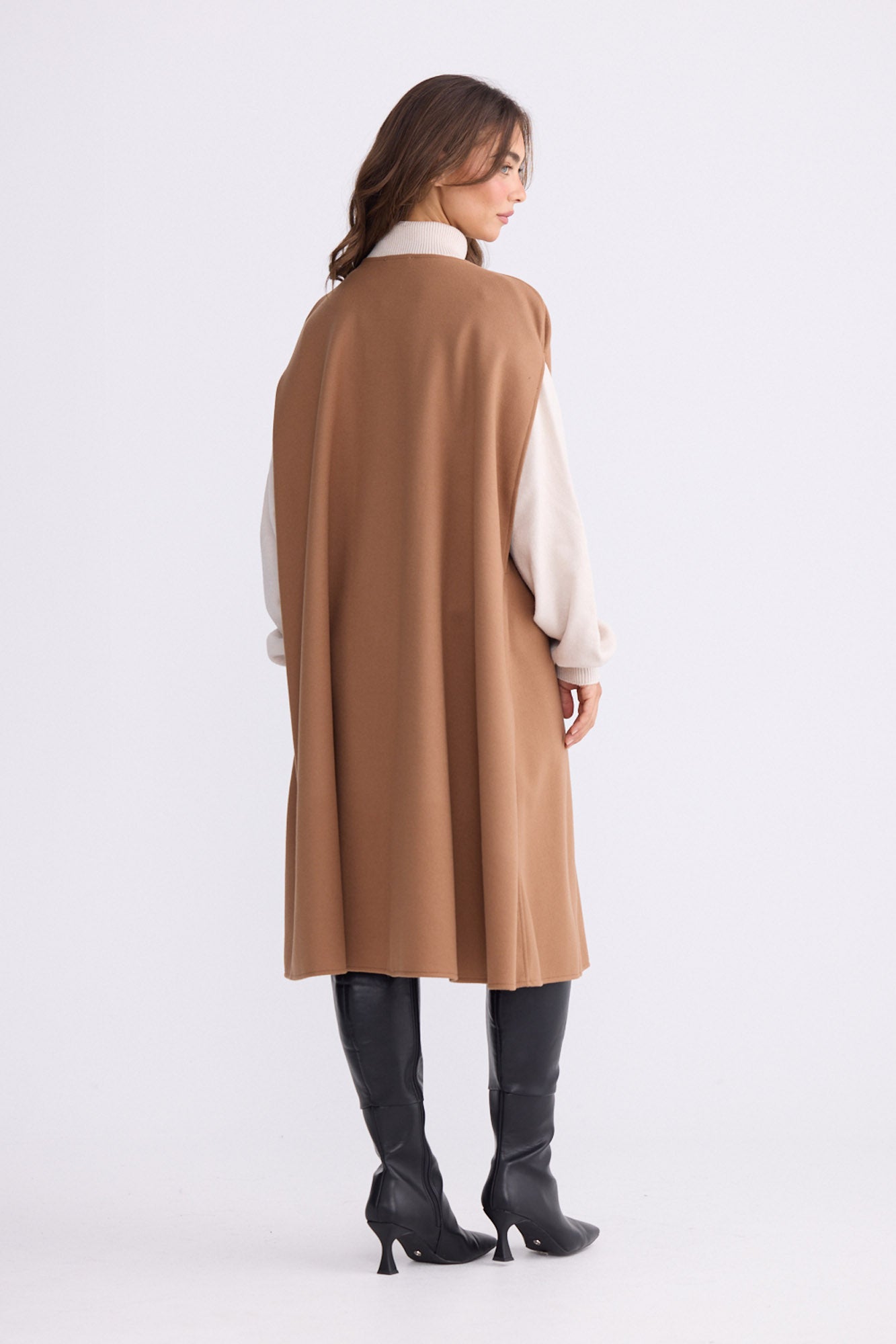 Model wearing Trini camel sleeveless cape with long fluid silhouette, alternate view on white background