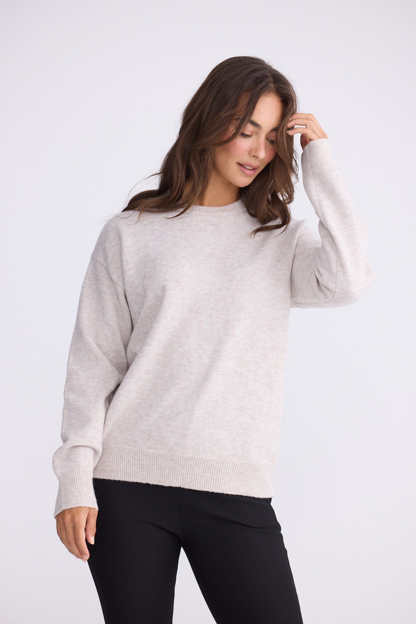 Model wearing Casey Knit - Oat, studio view on white background
