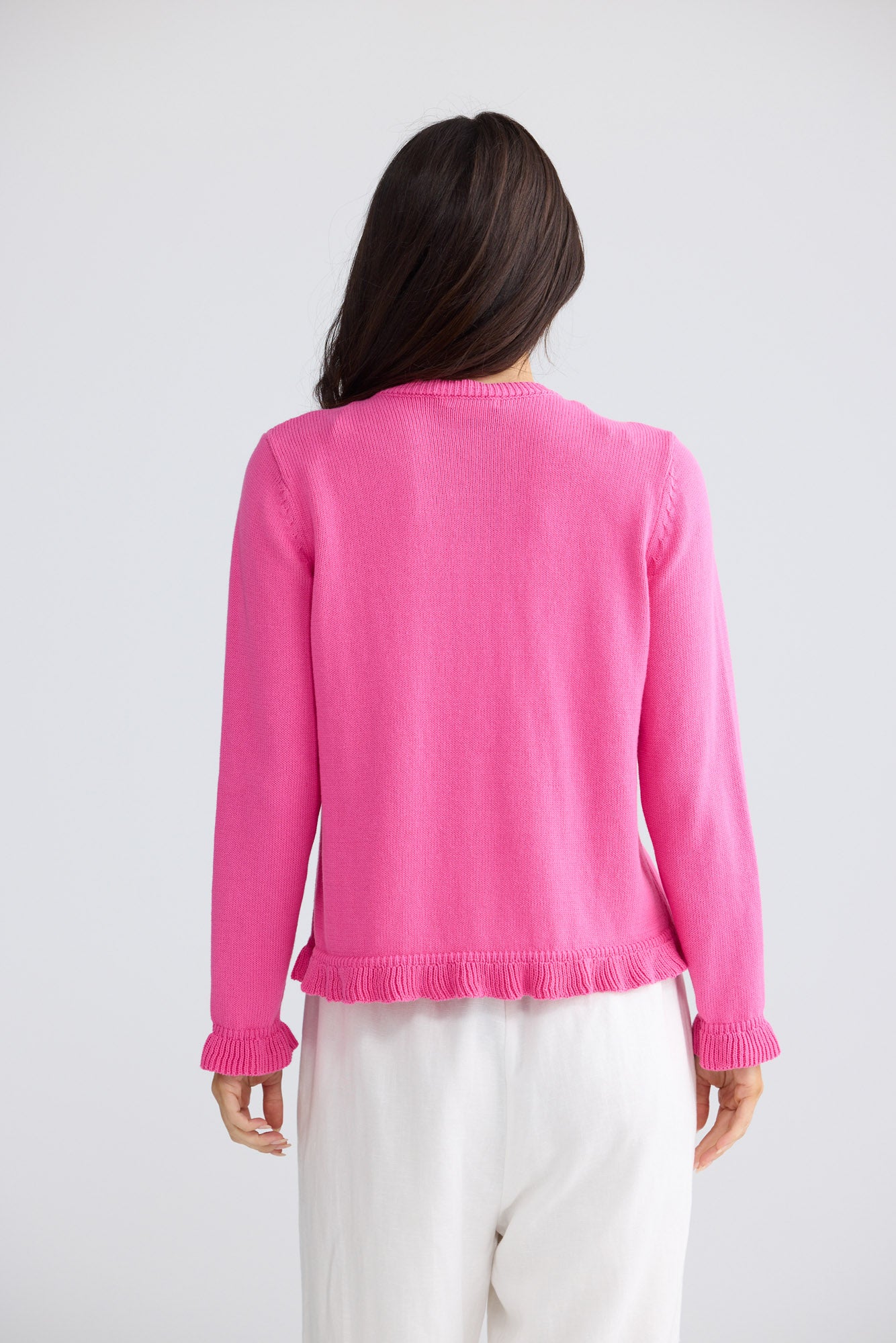Model wearing Lorrie Frill Cardi in hot pink by Brave + True, front view.
