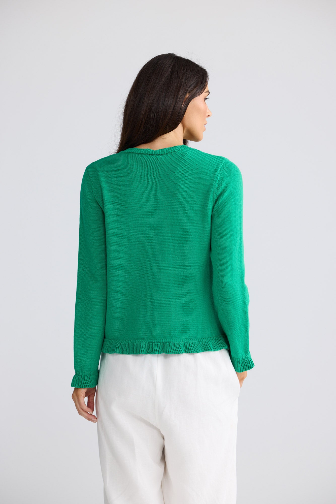 Model wearing Lorrie Frill Cardi in jade green by Brave + True, front view.