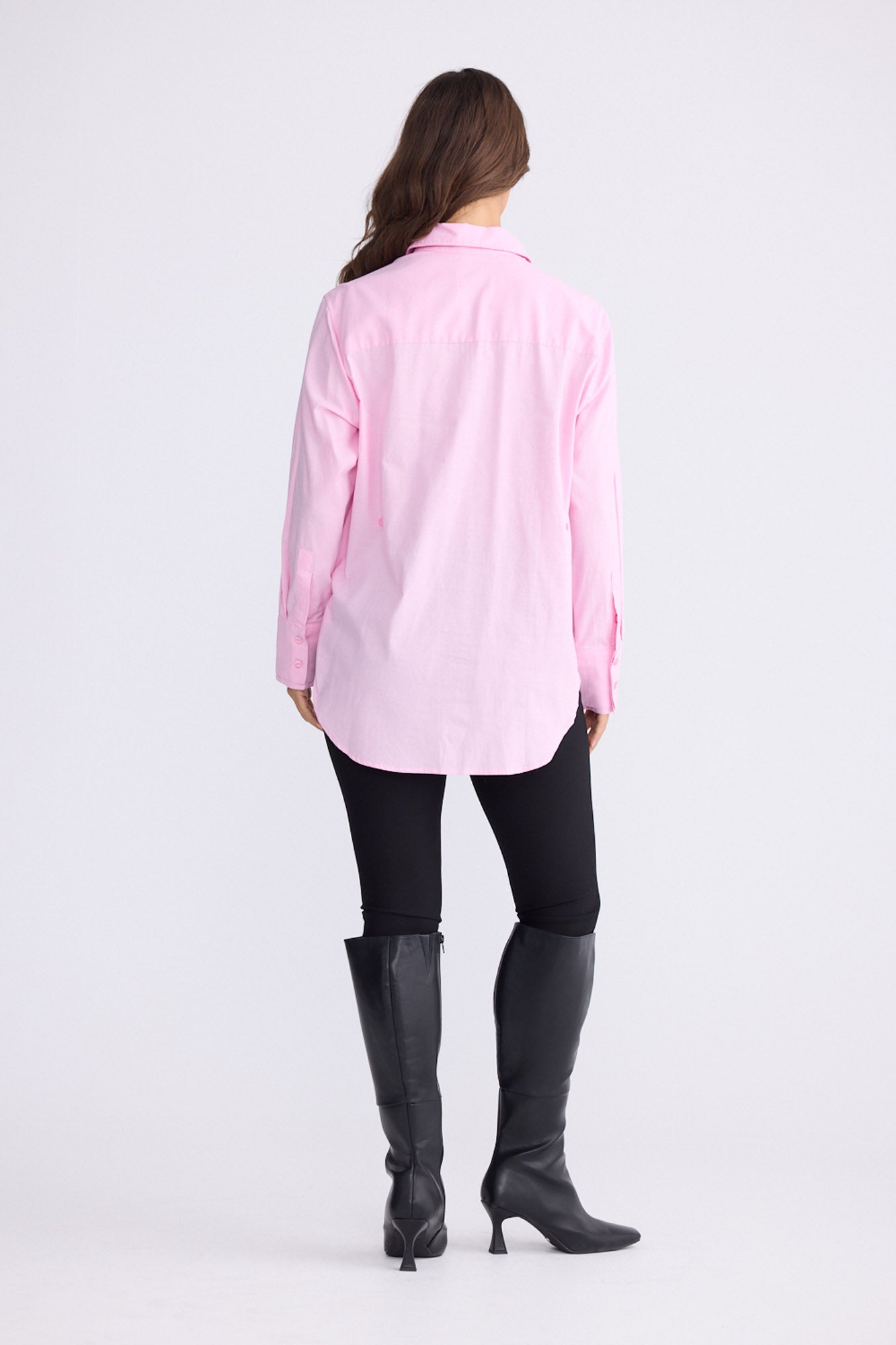 Model wearing Perry Shirt in pink with collar, back view on white background