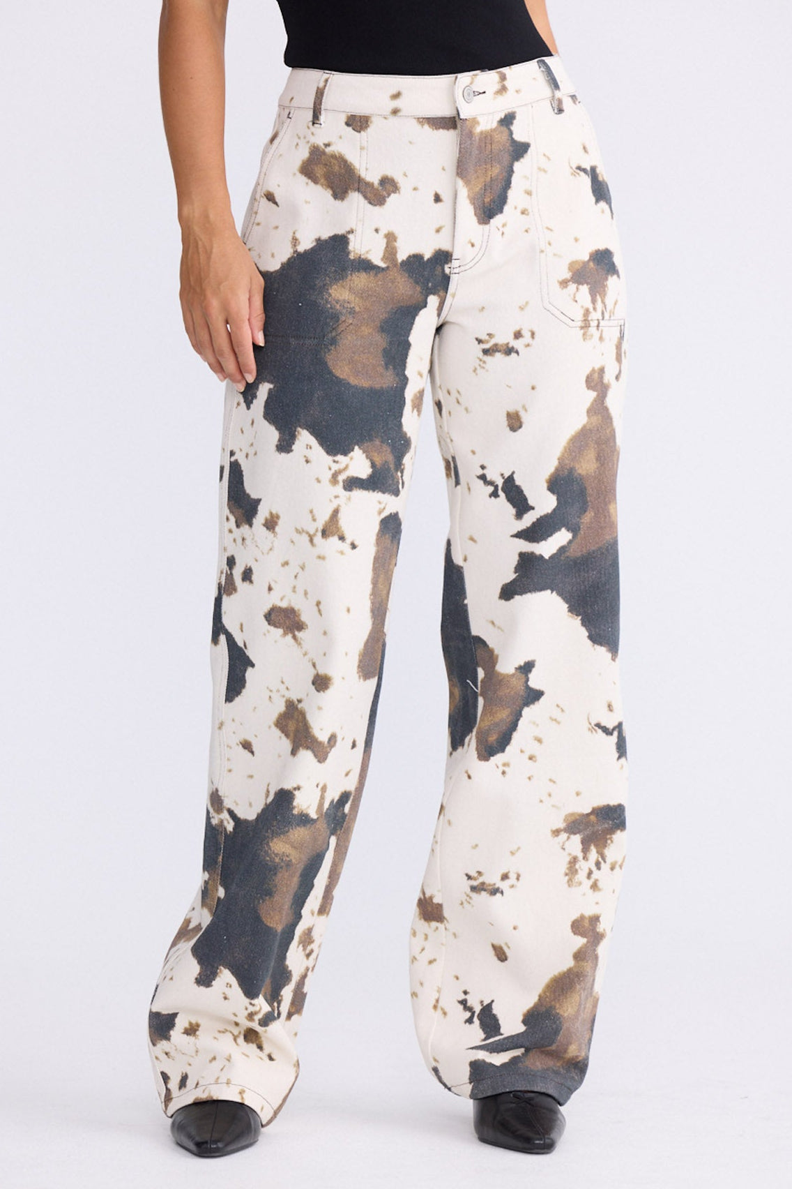 Model wearing Holstein Pant in abstract cow with cutaway pockets and straight-leg shape, front view on white background