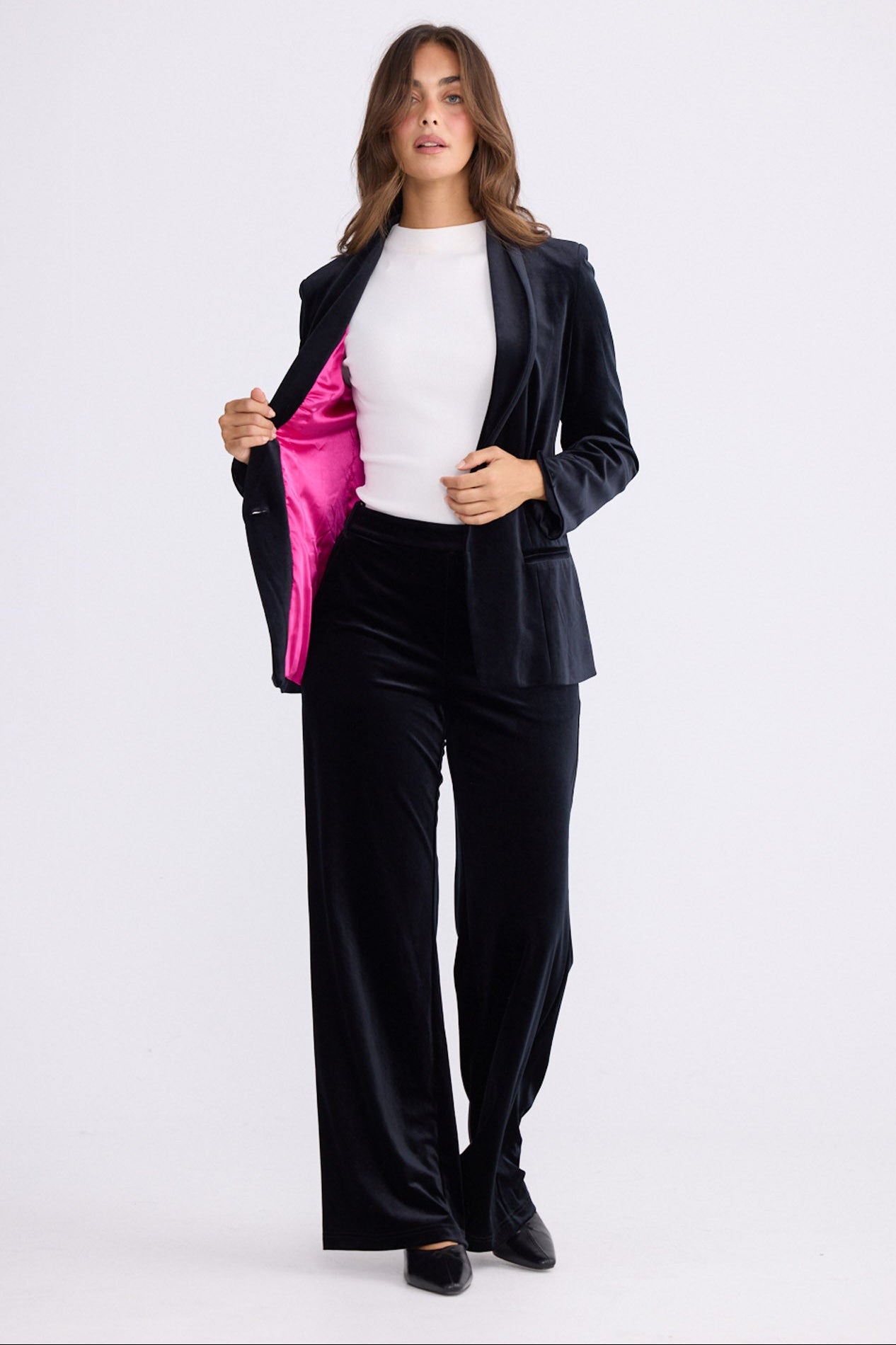 Model wearing Lillia Blazer in black with long sleeves, front view on white background