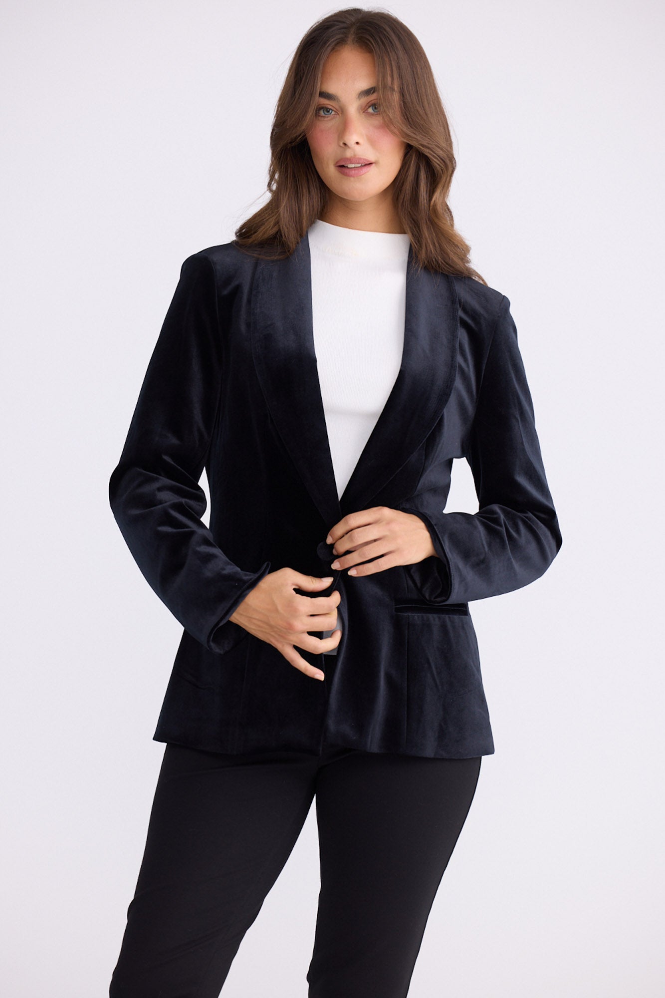 Model wearing Lillia Blazer in black with long sleeves, side view on white background