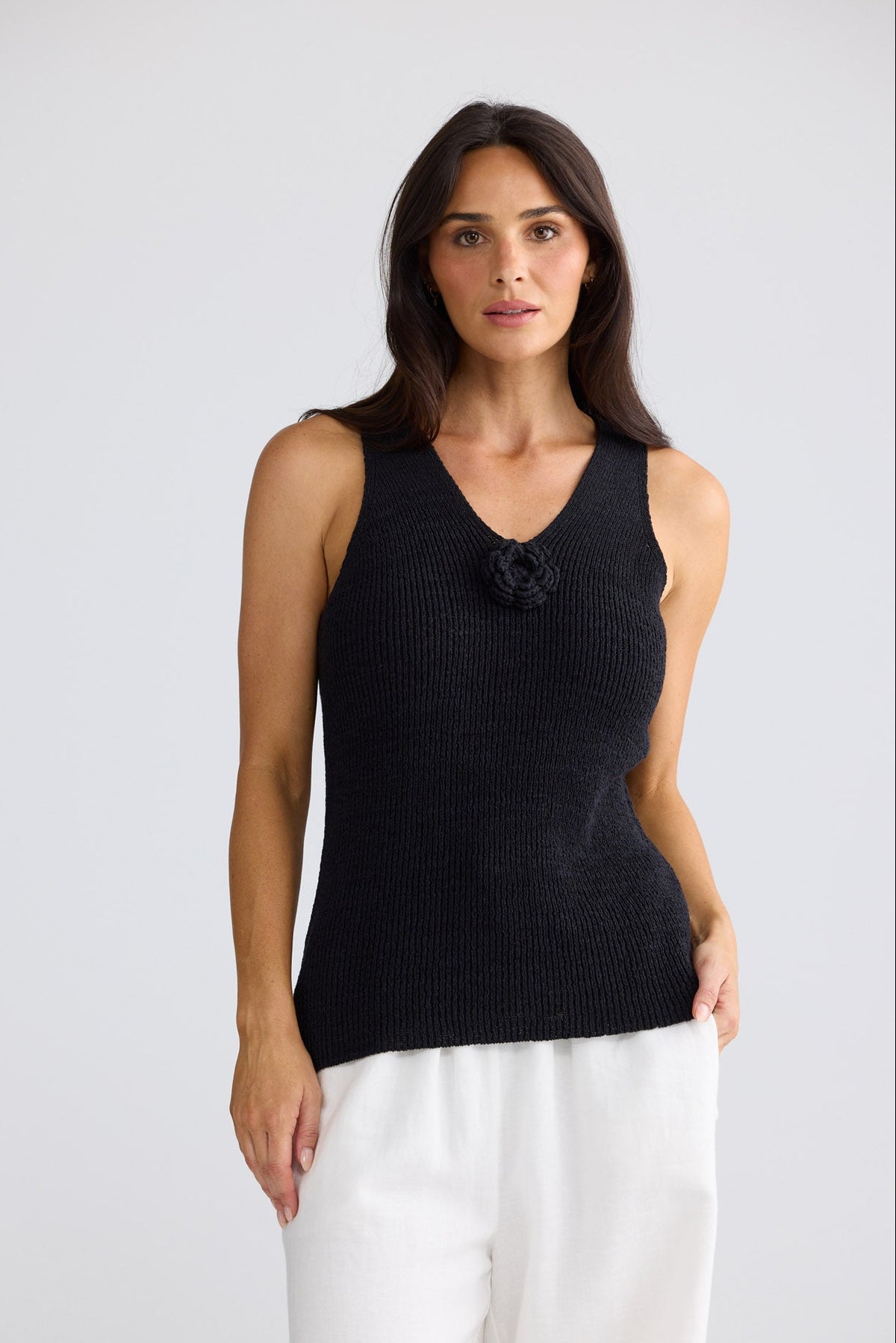 Model wearing Rosalie Knit Tank in black by Brave + True, front view showing floral motif.