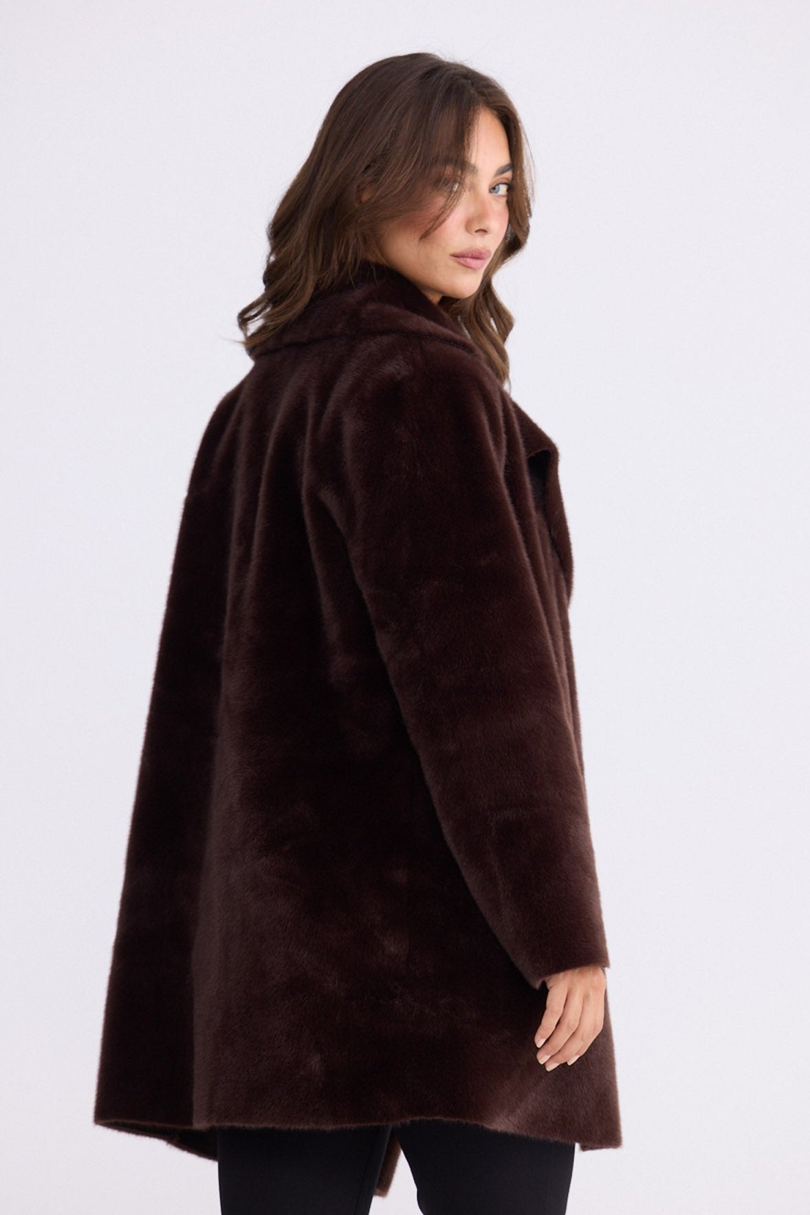 Model wearing Odette Fur Coat in brown with notched lapels and long sleeves, front view on white background