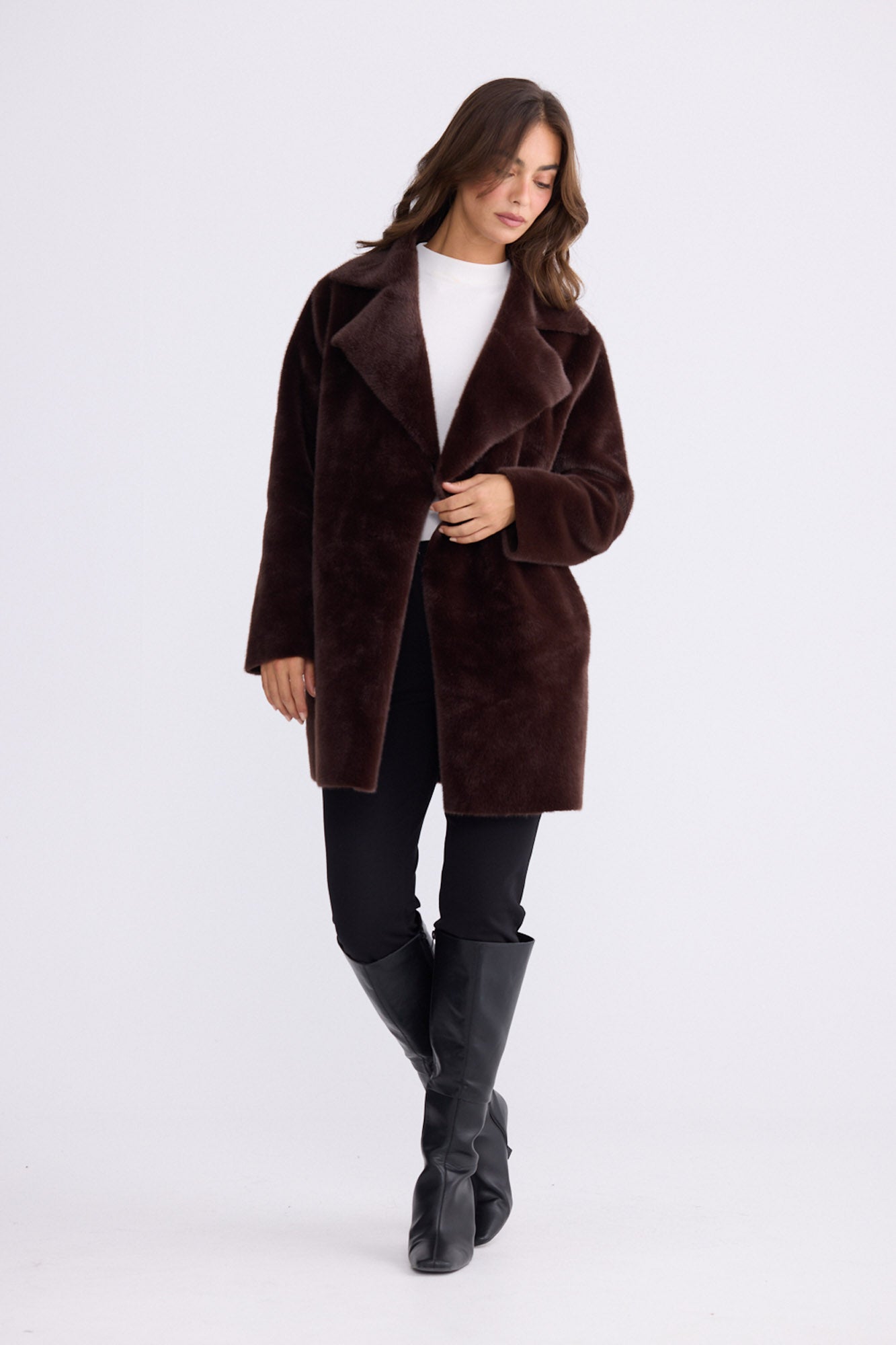 Model wearing Odette Fur Coat in brown with notched lapels and long sleeves, front view on white background