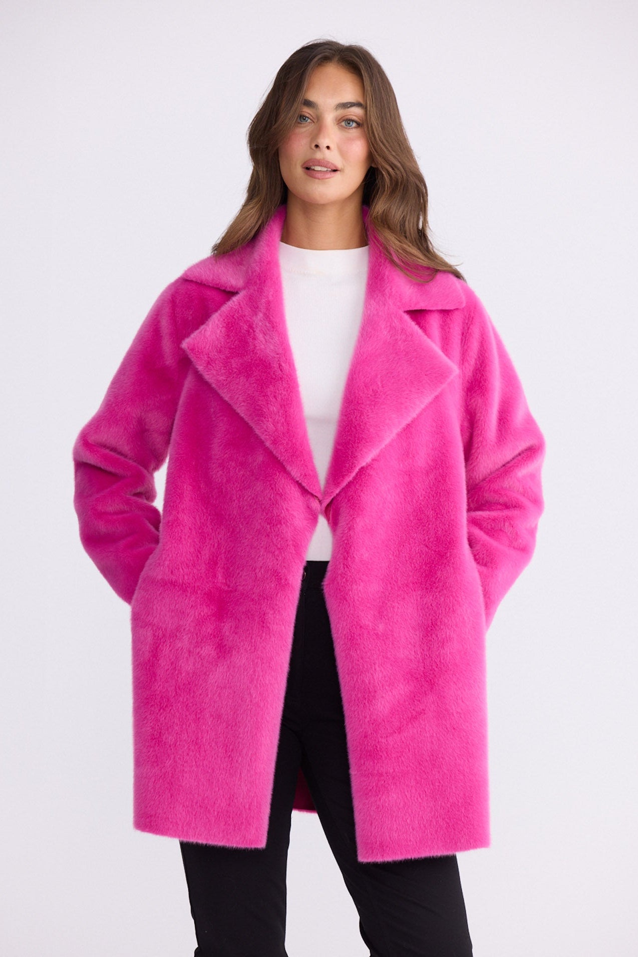 Model wearing Odette Fur Coat in pink with notched lapels and long sleeves, back view on white background