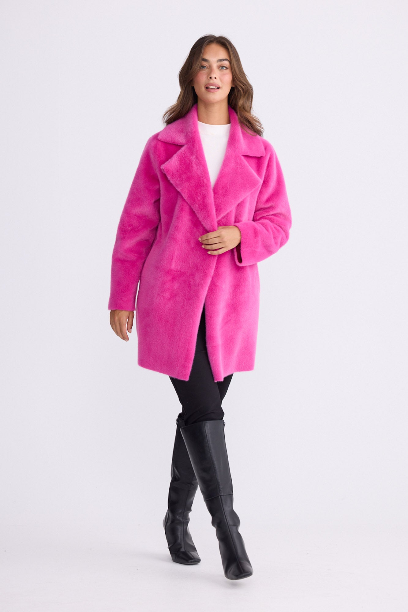 Model wearing Odette Fur Coat in pink with notched lapels and long sleeves, front view on white background