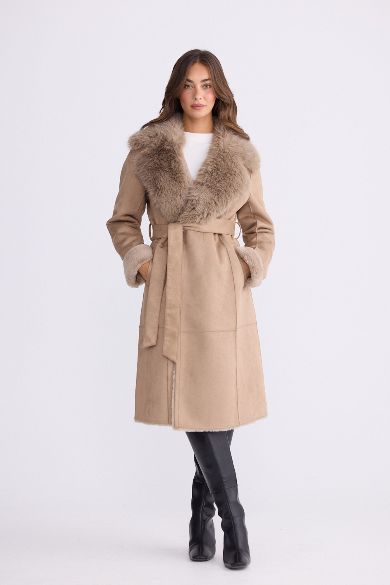 Model wearing Rosamund Fur Coat in beige with notched lapels and waist tie, back view on white background